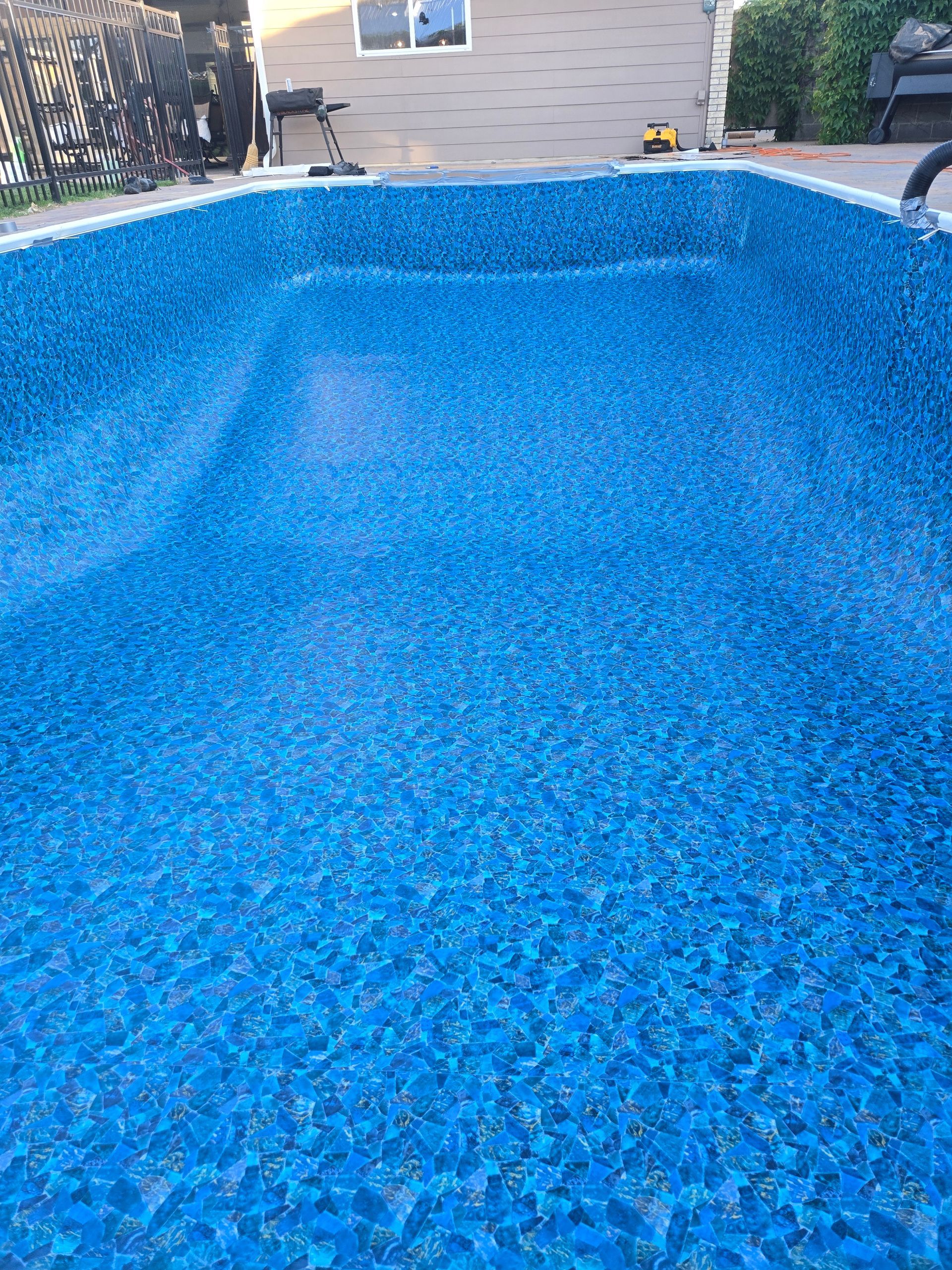 A blue and white beach ball is floating in a swimming pool.