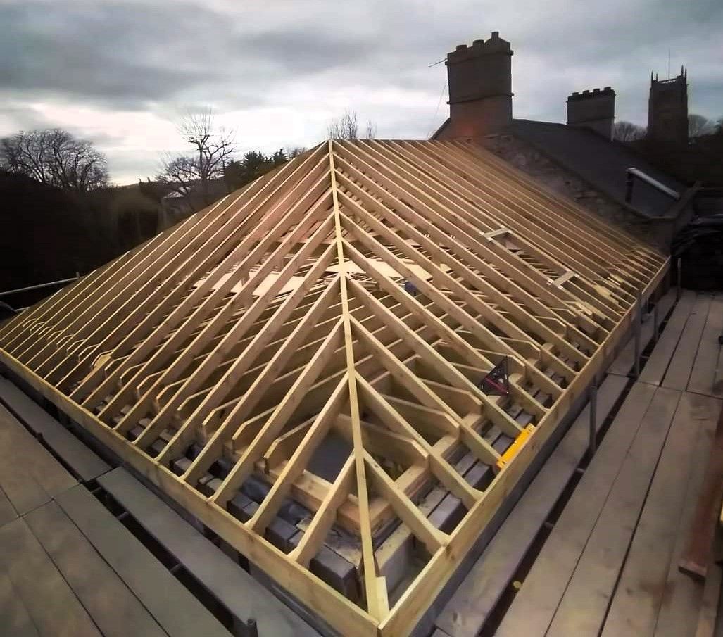 Roof under construction with exposed wooden rafters on a house, viewed from above