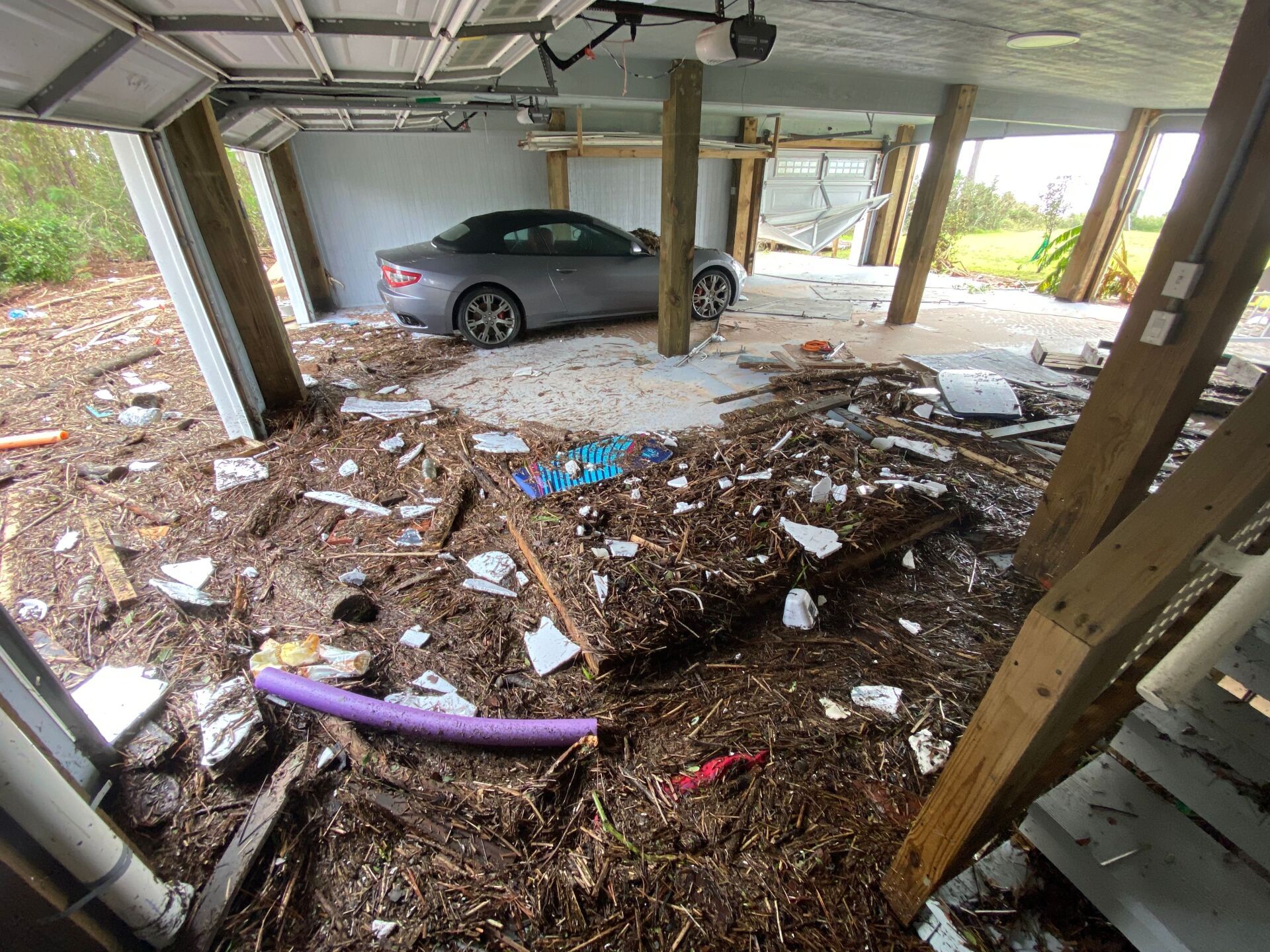 A car is parked in a garage that has been flooded.