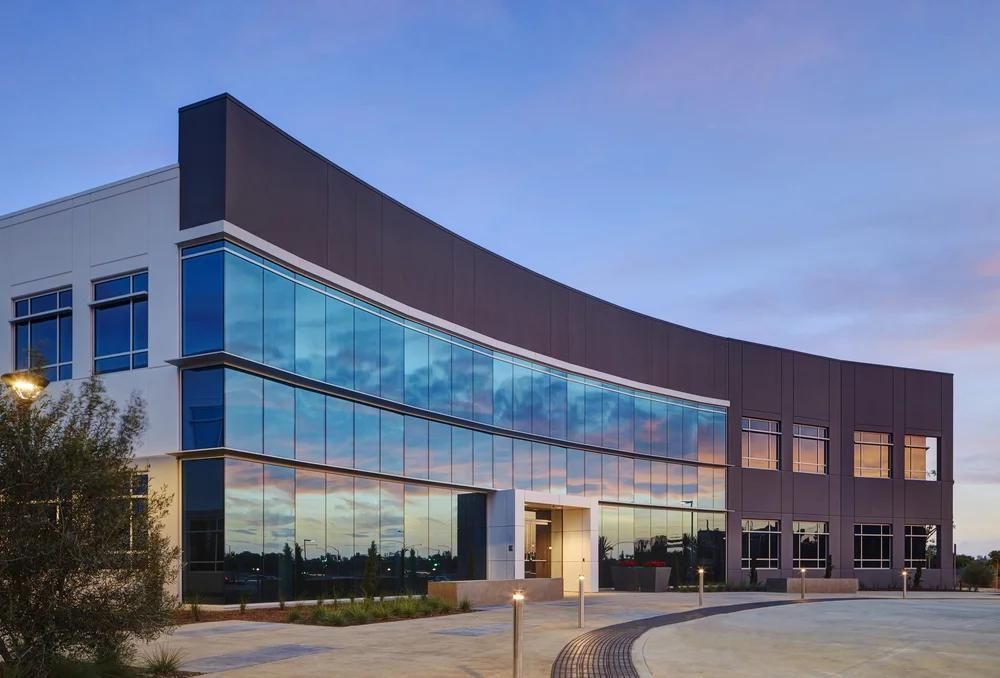 Modern office building with curved glass facade at dusk