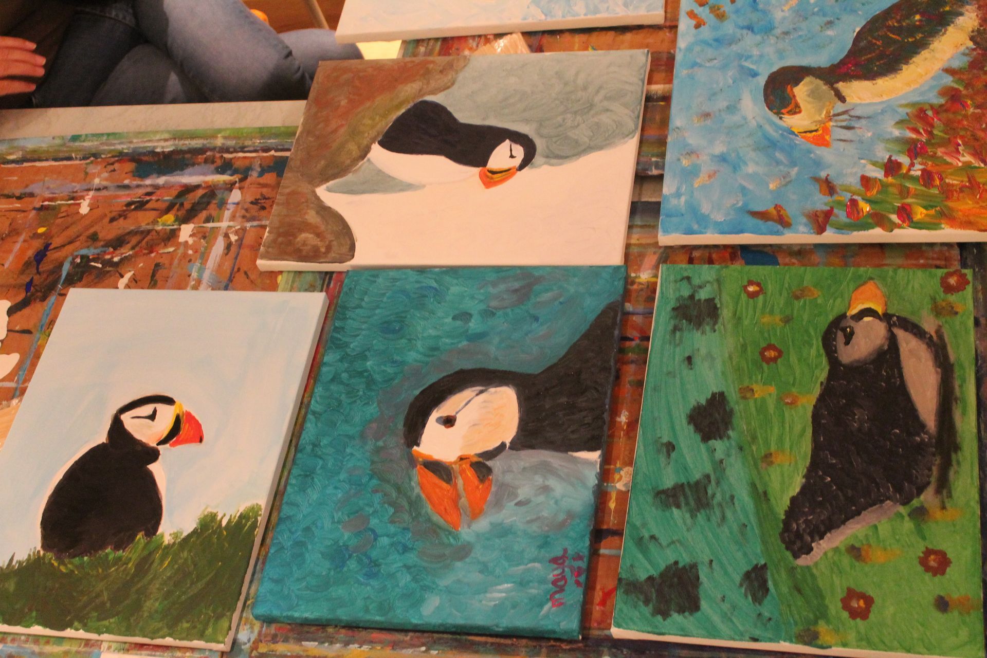 Een stel schilderijen van vogels liggen op een tafel