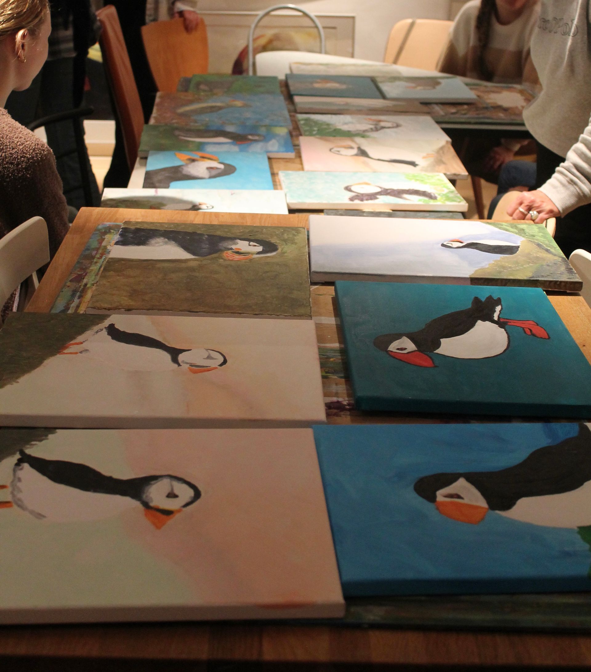 Op een tafel staan ​​verschillende schilderijen van pinguïns