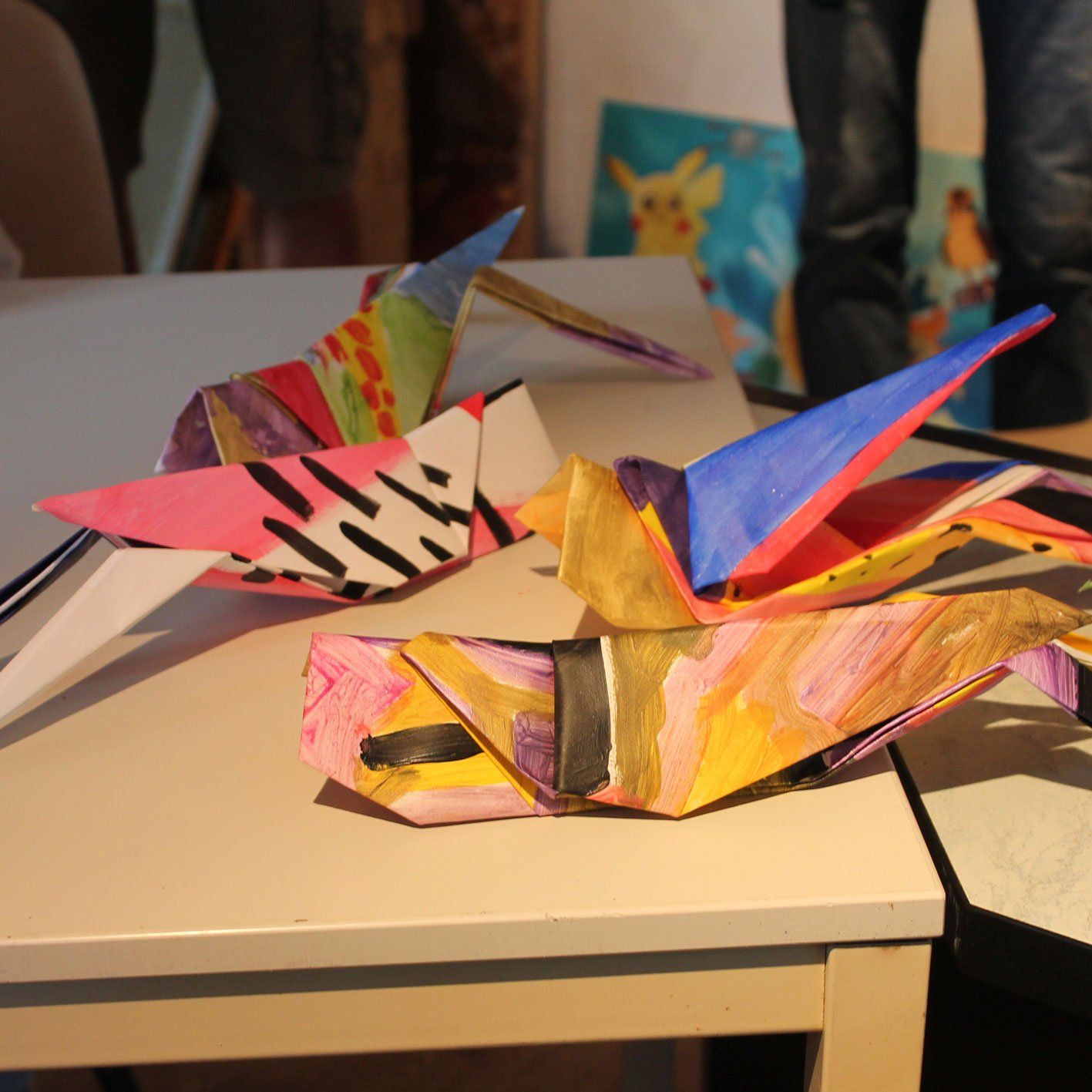 Twee kleurrijke origamivogels zitten op een tafel