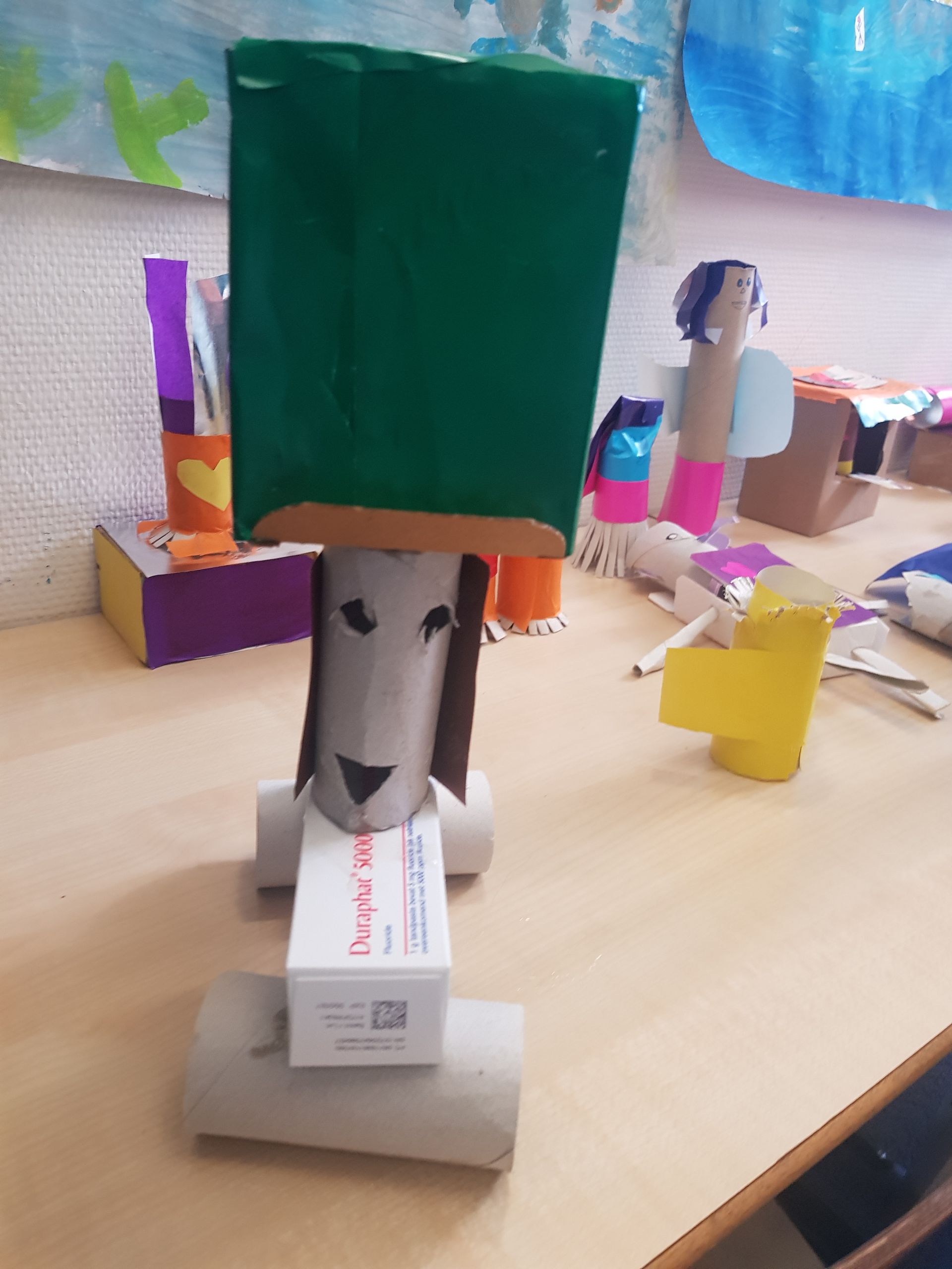 Een leeuw gemaakt van wc-papierrollen met een groene hoed