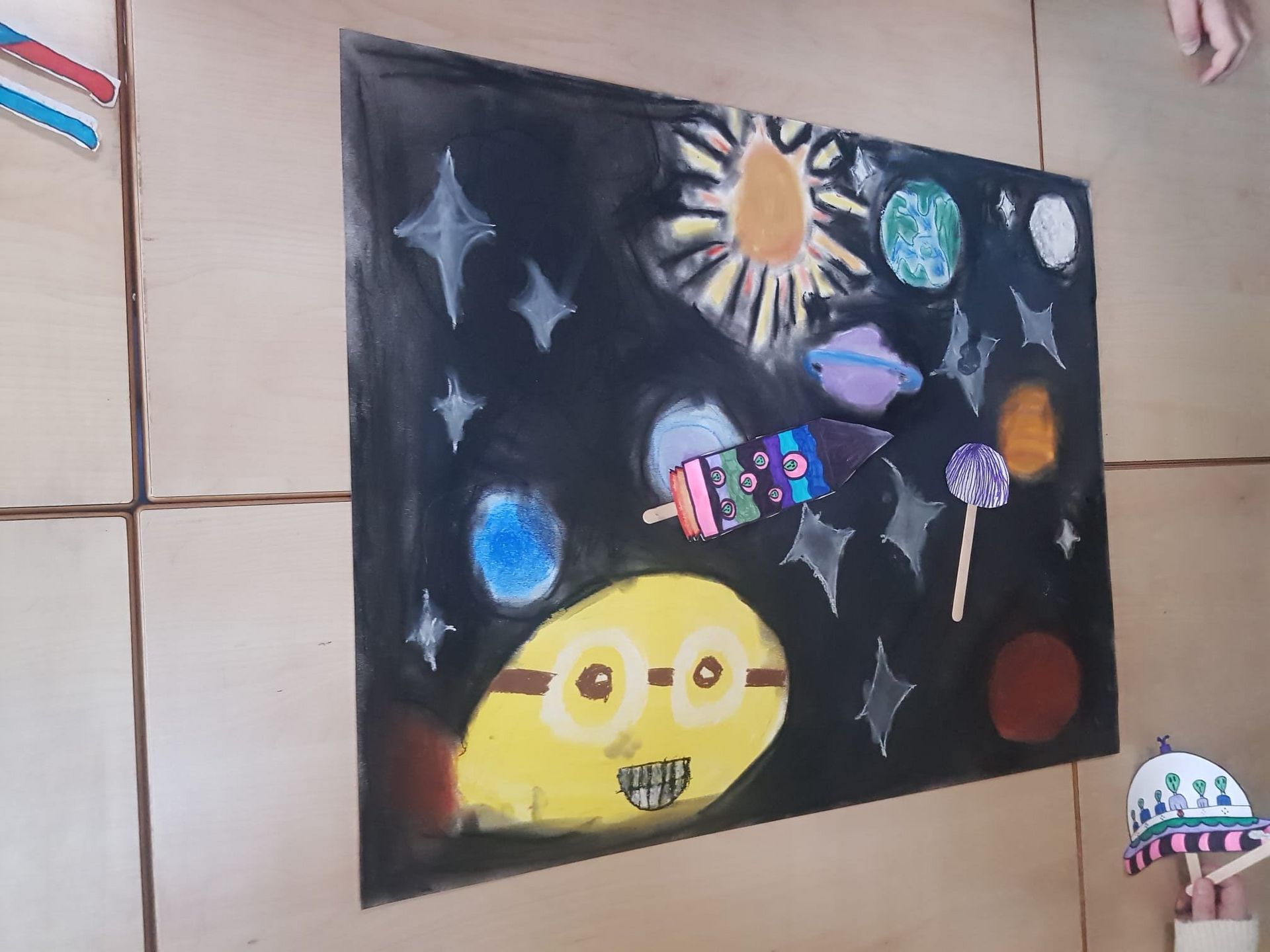 Een kindertekening van sterren en planten die door de ruimte zweven