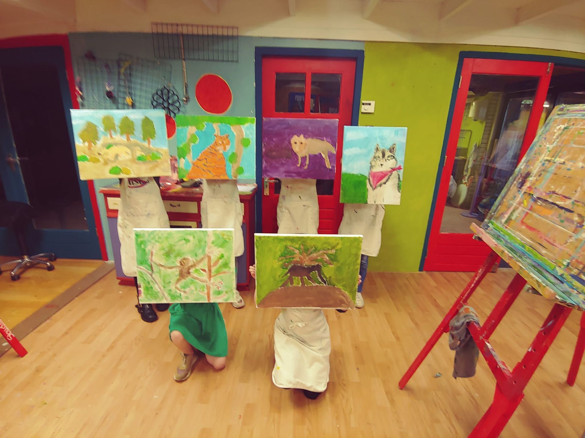 Een groep jongeren die schilderijen voor hun gezicht houden