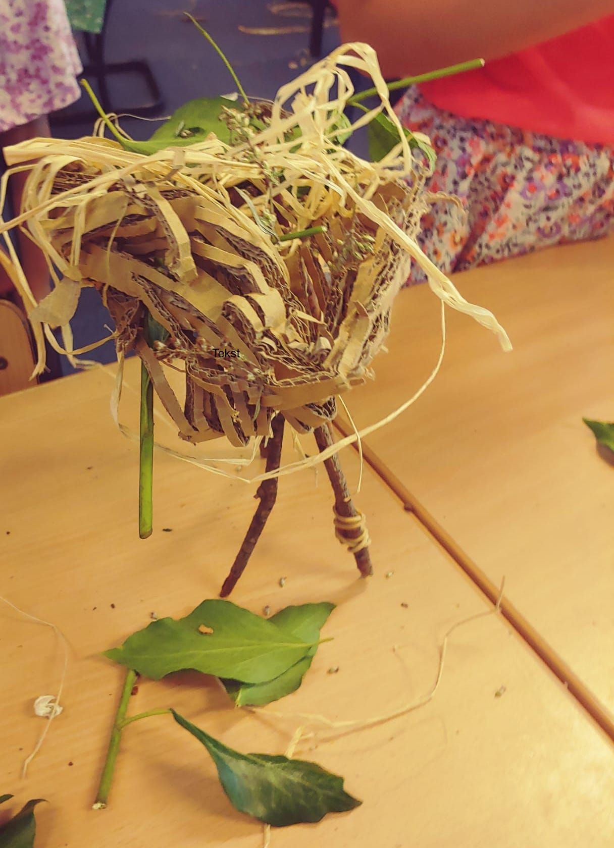 een nest gemaakt van takjes en blaadjes in de kunstles