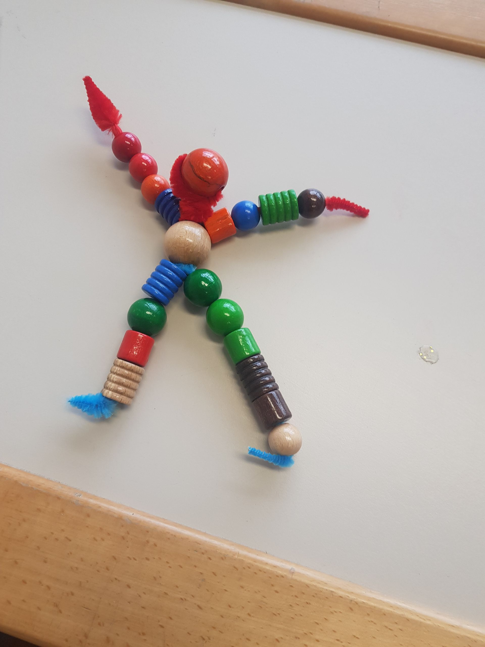 Een persoon gemaakt van kralen op een wit bord
