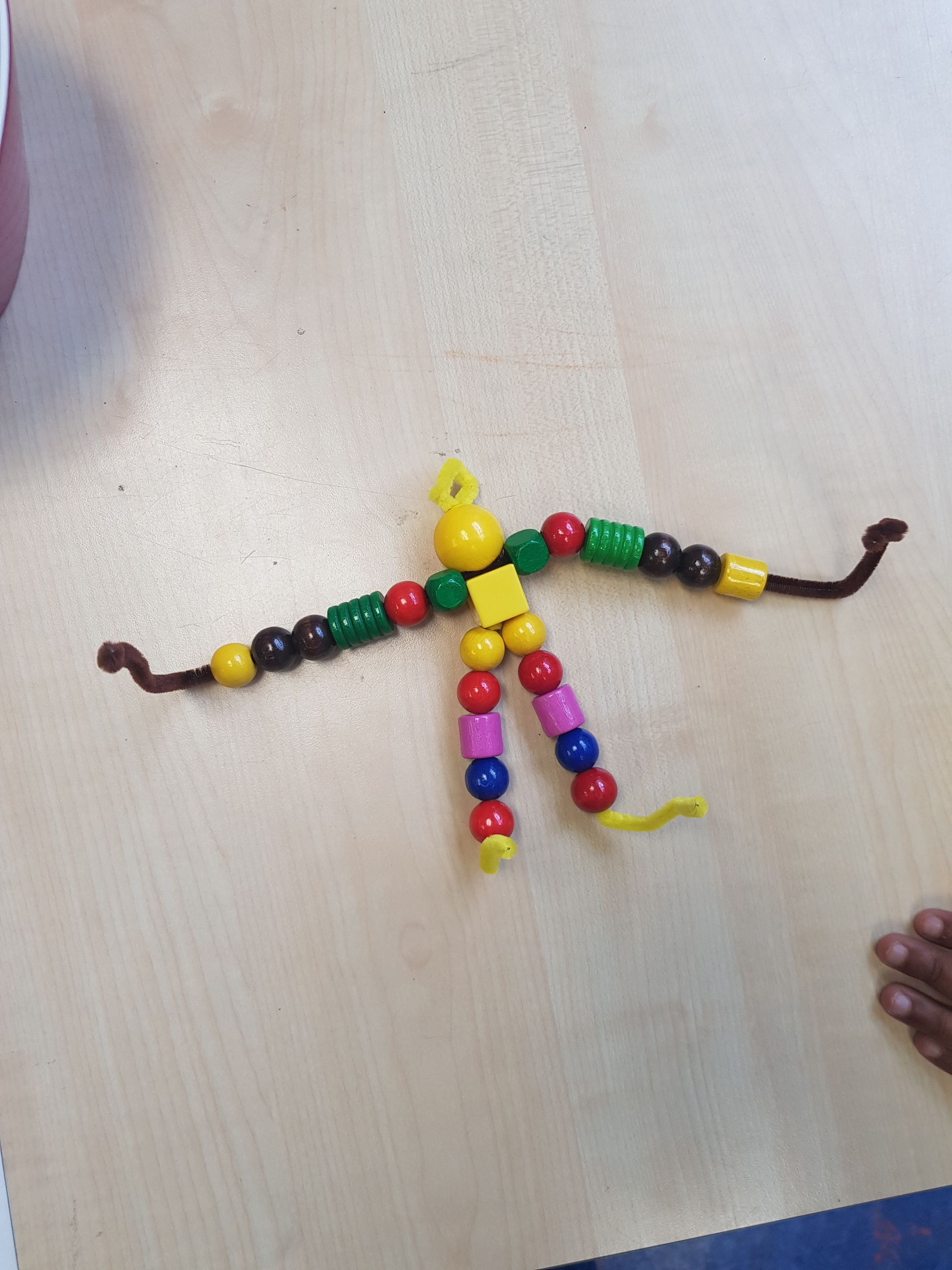 Een persoon gemaakt van kralen en chenille draden