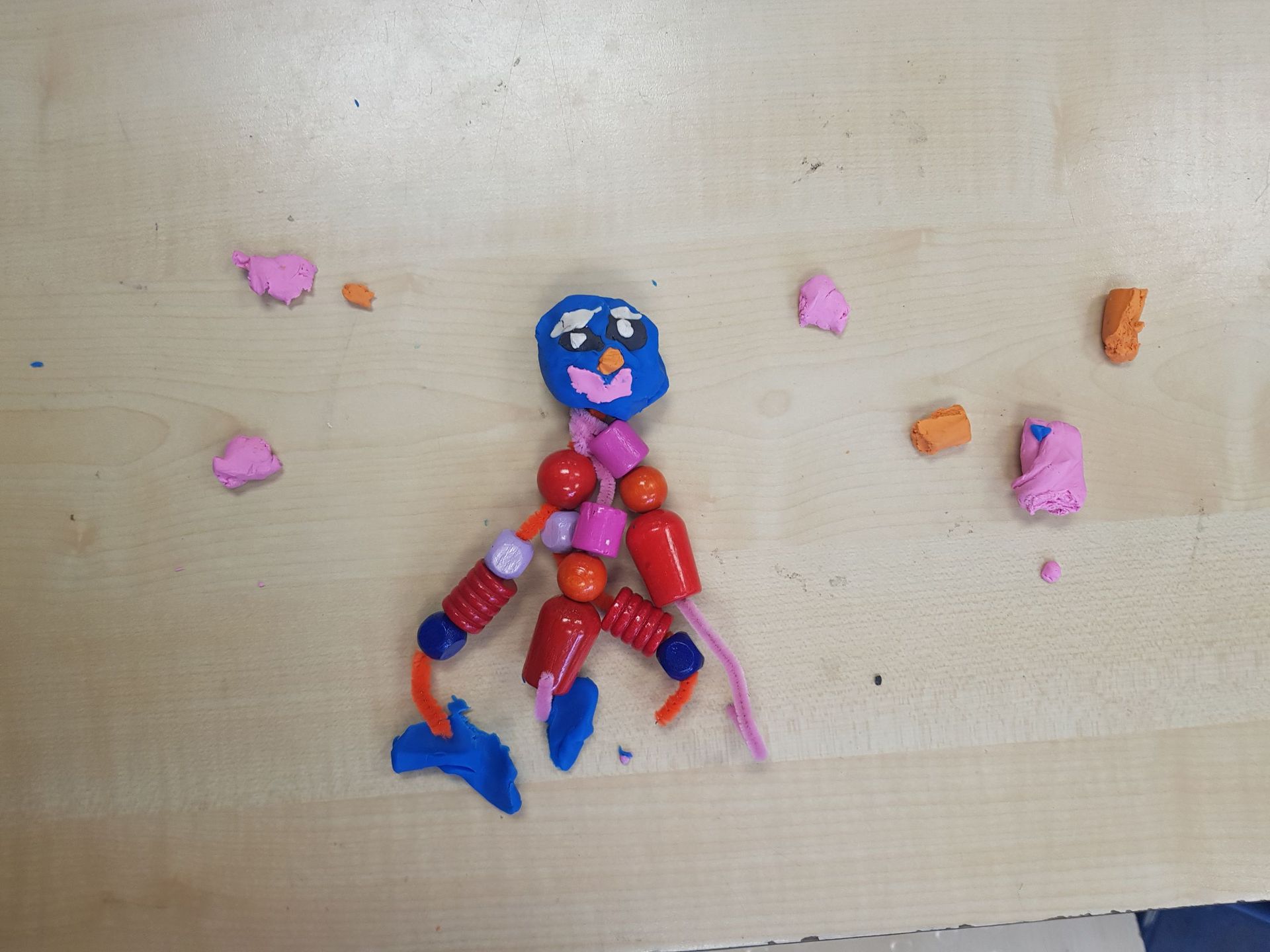 Een speeltje gemaakt van kralen en pijpenragers op een tafel