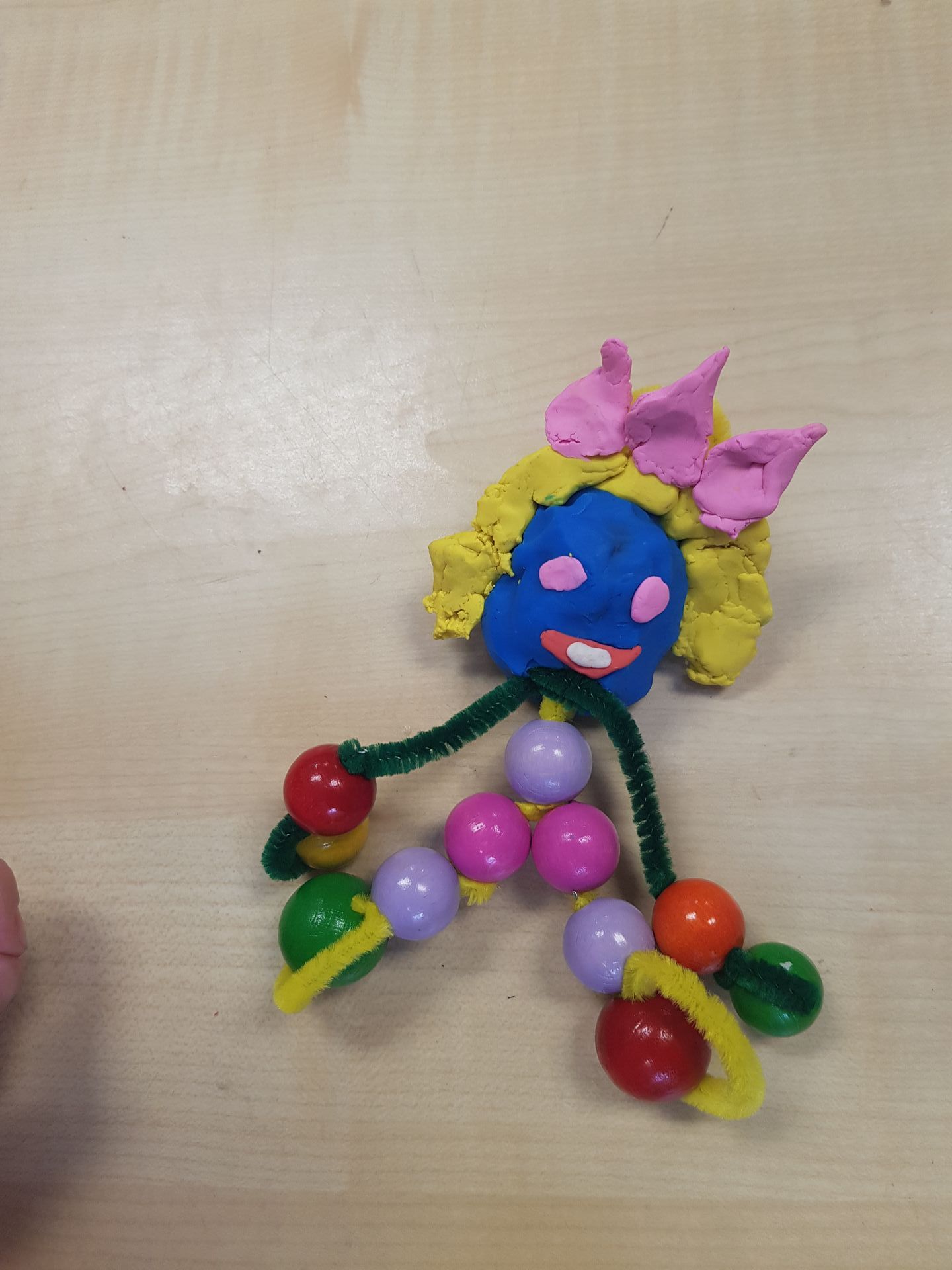 Een prinsesje gemaakt van klei en kralen op een tafel
