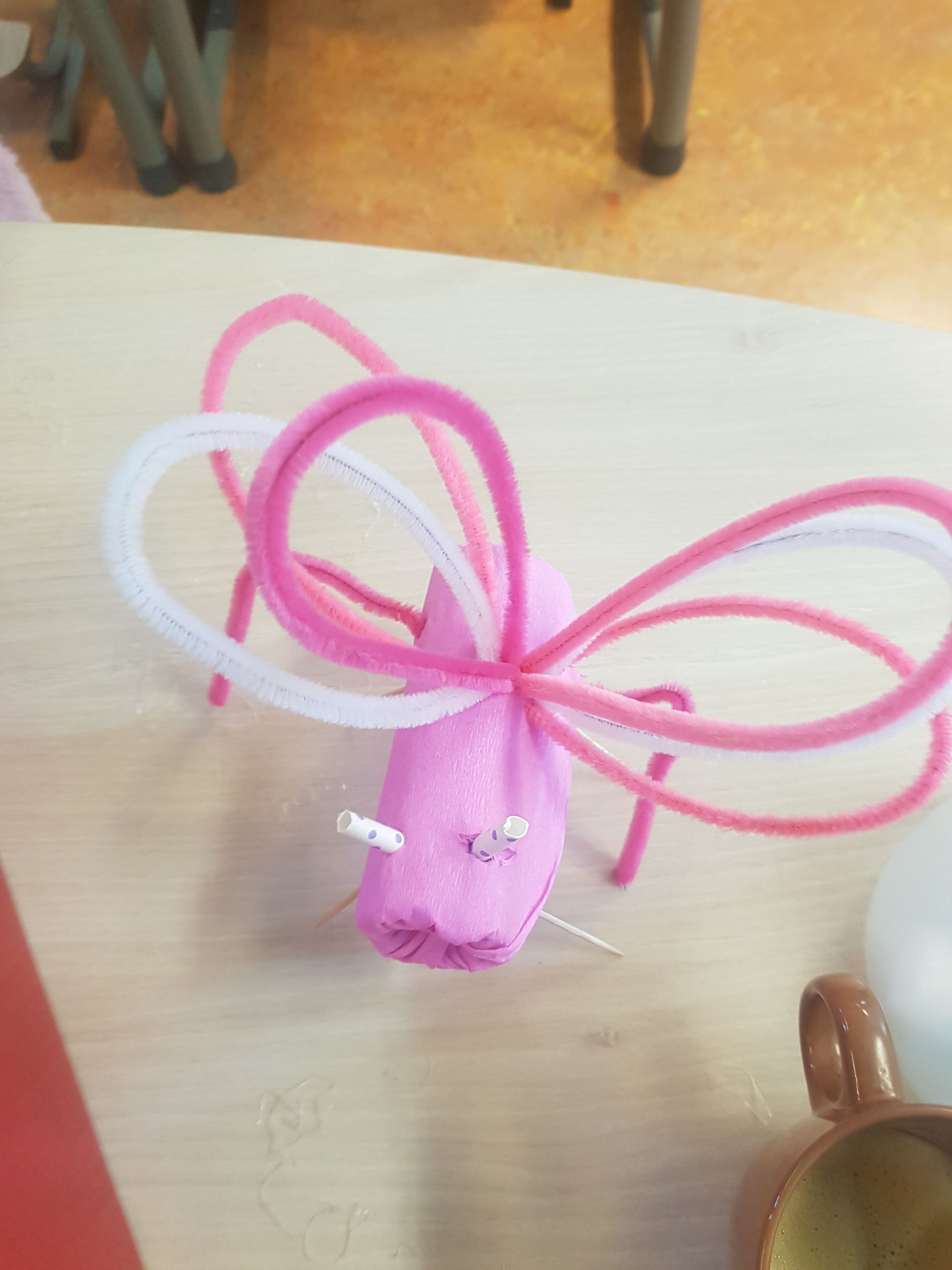 Een roze en witte vlinder gemaakt van pijpenragers