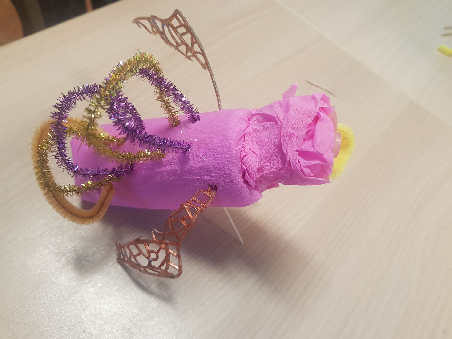 Een roze voorwerp met paarse en gouden wervelingen erop