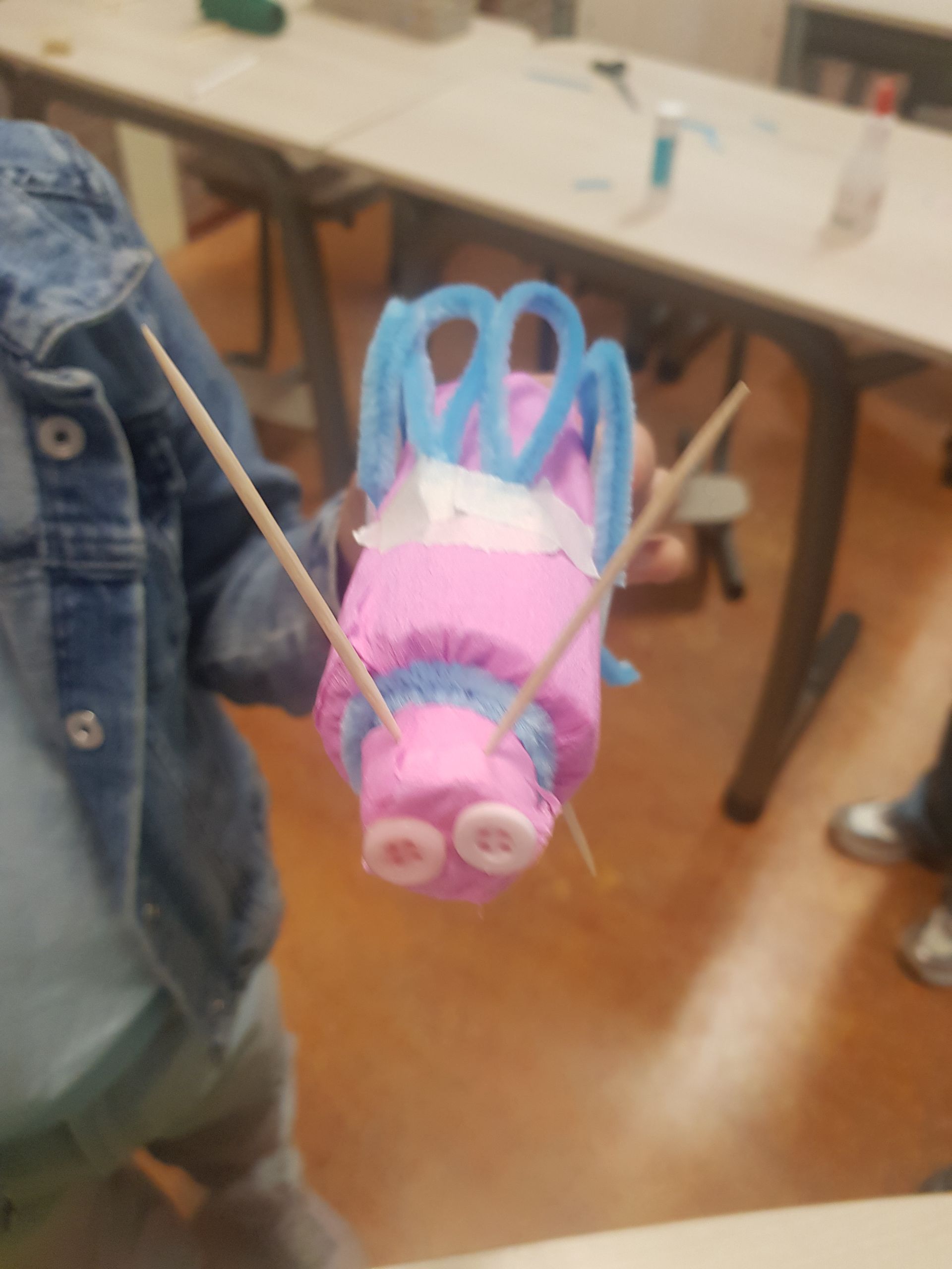 Een persoon houdt een roze speeltje vast met tandenstokers erin