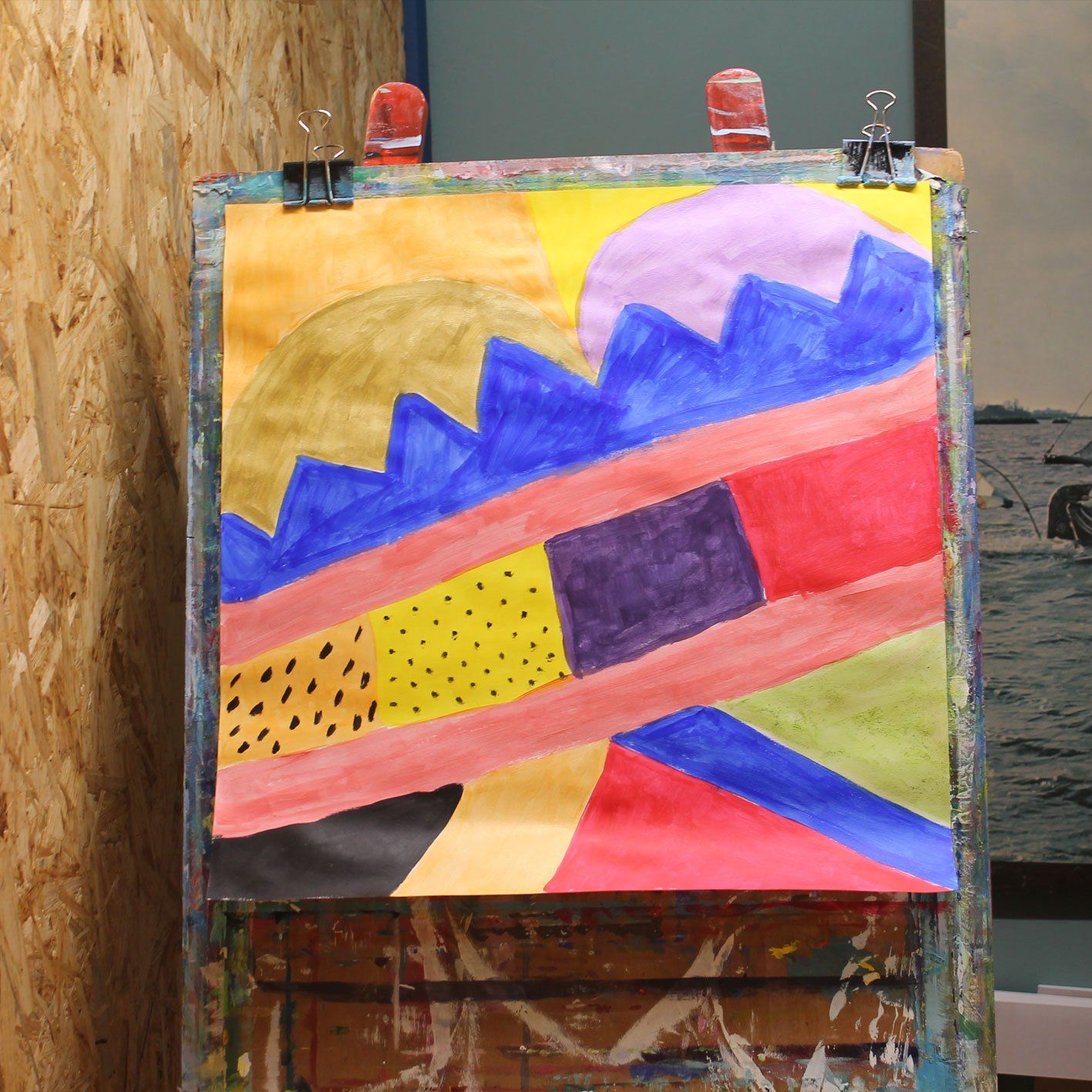 Een kleurrijk schilderij hangt op een houten ezel