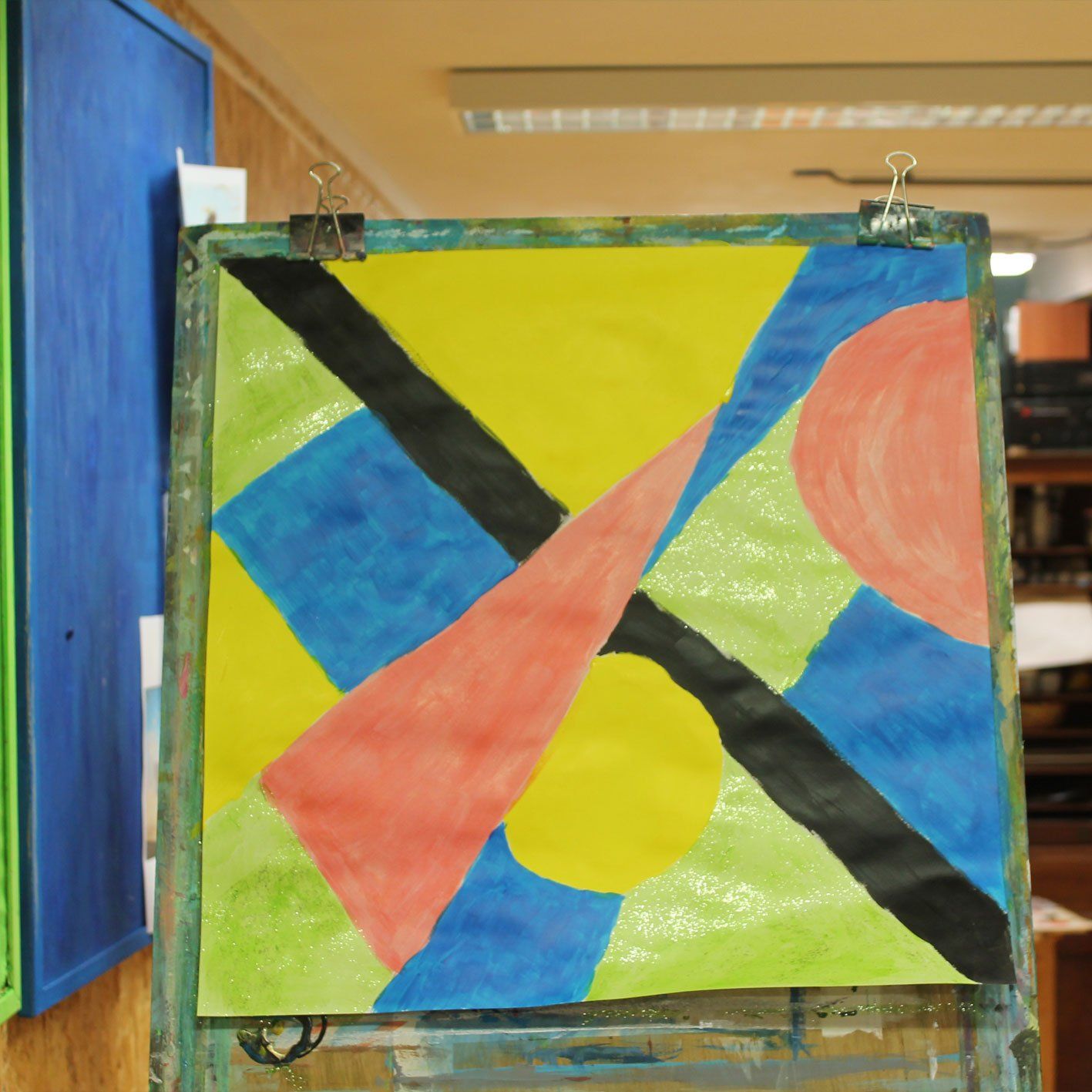 Een kleurrijk schilderij hangt op een houten ezel