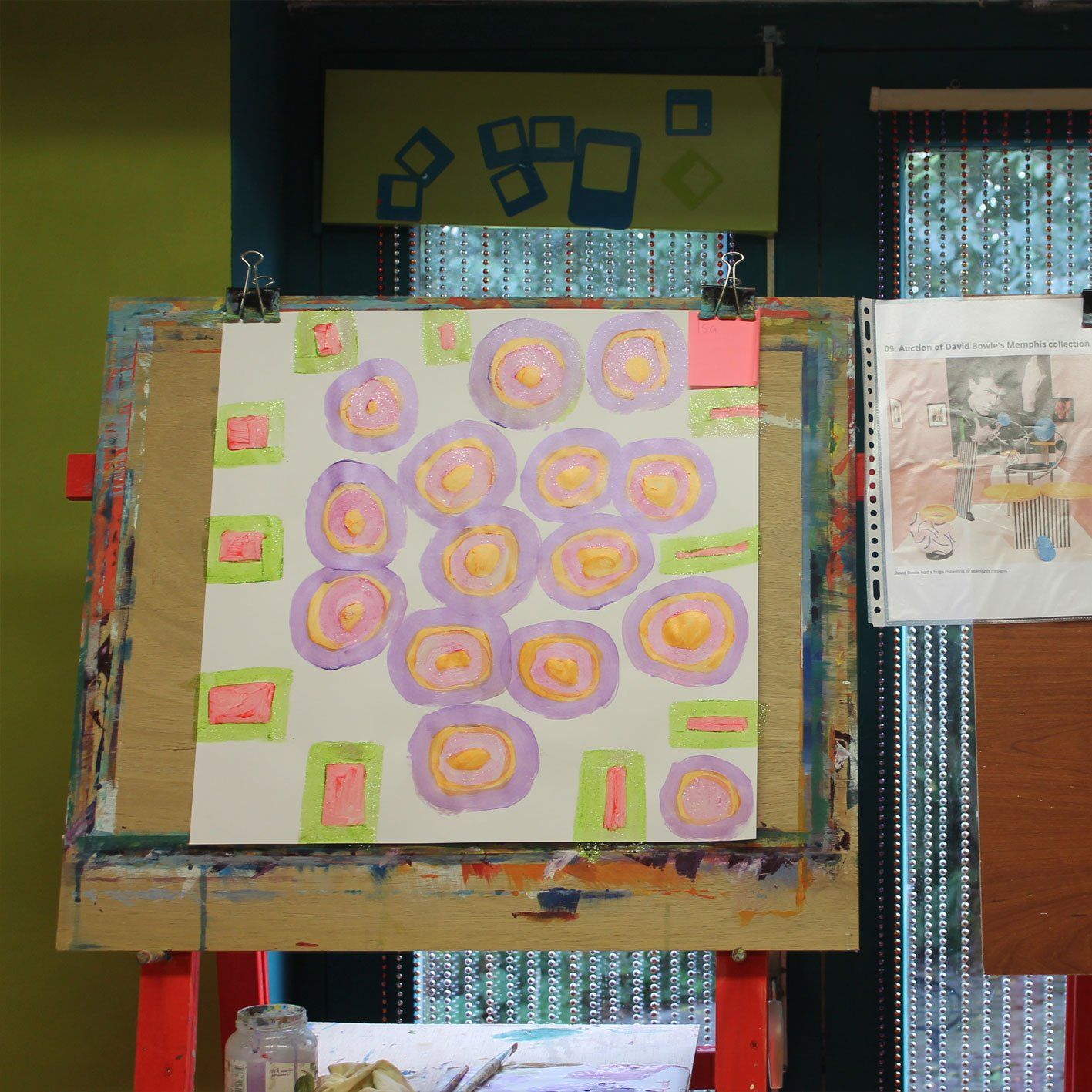 Een schilderij van paarse en oranje cirkels op een wit bord