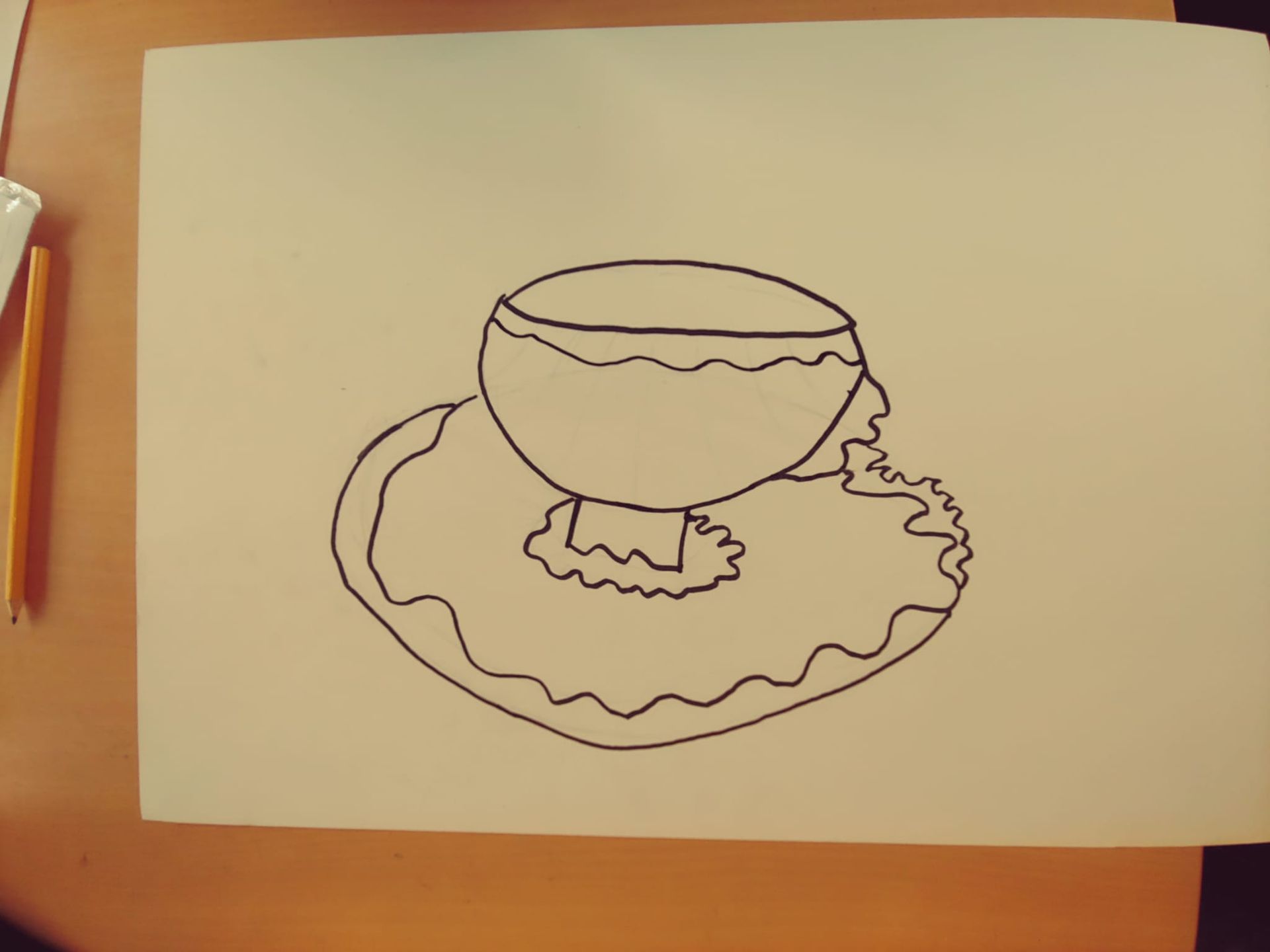 Een zwart-wit tekening van een kopje op een schotel