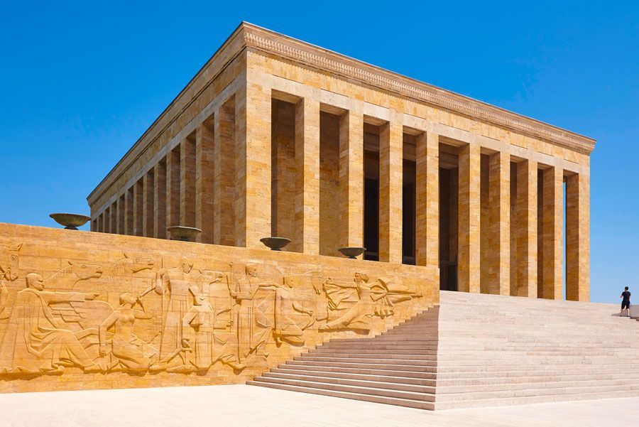 Mausoleo de Anıtkabir en Ankara, Turquía. Edificio de piedra beige con columnas bajo un cielo azul; escalones conducen a la entrada.