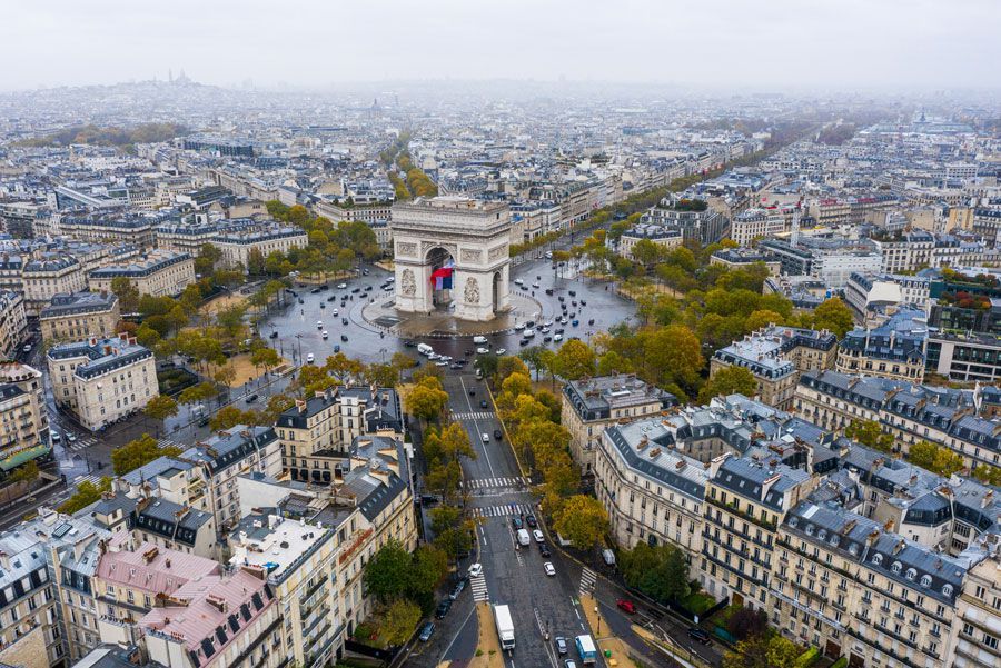 Vista aérea del Arco del Triunfo en París, Francia. El monumento está rodeado por una rotonda concurrida y flanqueado por avenidas arboladas.
