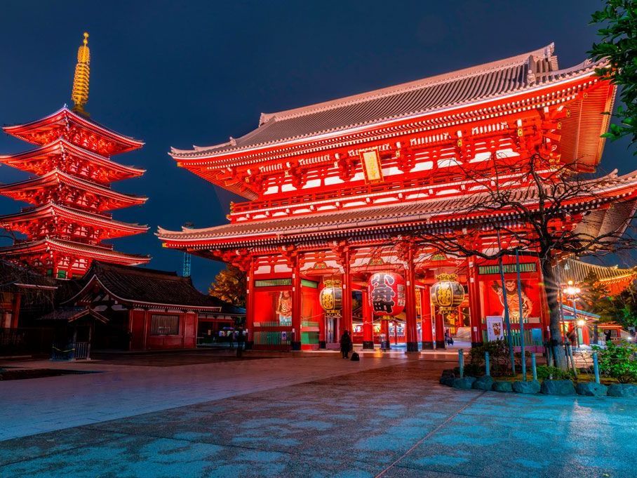 Vista nocturna del Templo Senso-ji en Tokio, Japón, iluminado en rojo. Incluye la pagoda y la puerta principal.