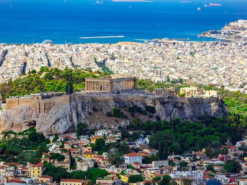 Acrópolis de Atenas con el Partenón, un templo histórico, en la cima de una colina con vistas a la ciudad.