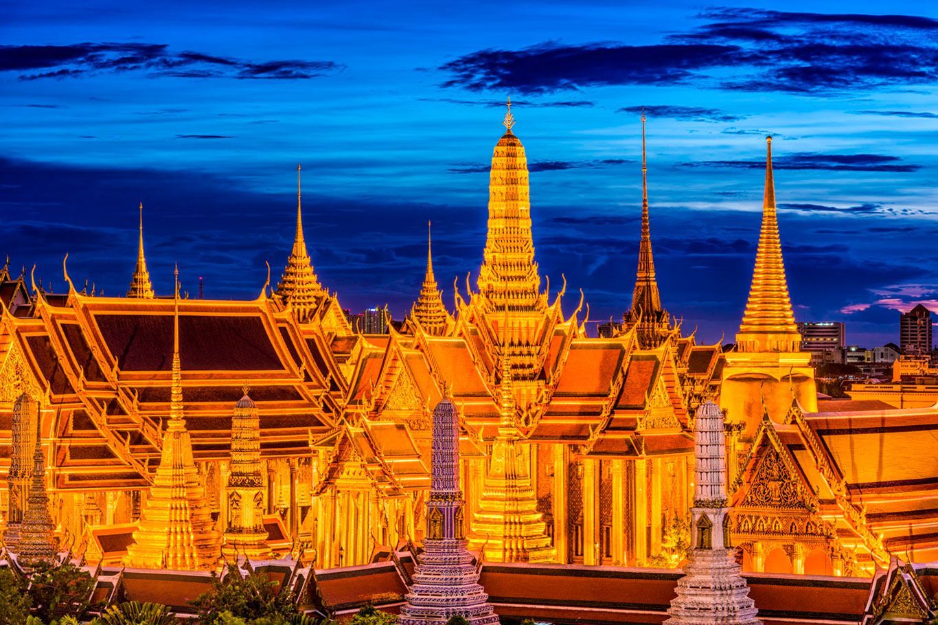 Gran Palacio Dorado de Bangkok iluminado al anochecer.
