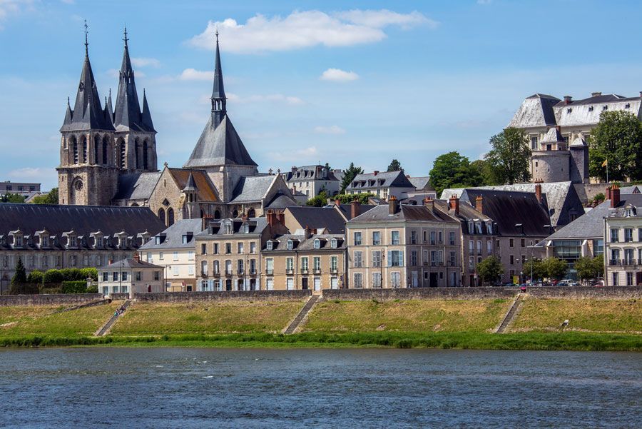 Una vista de la histórica ciudad de Amboise, Francia, con una catedral con agujas y edificios que bordean el río Loira.