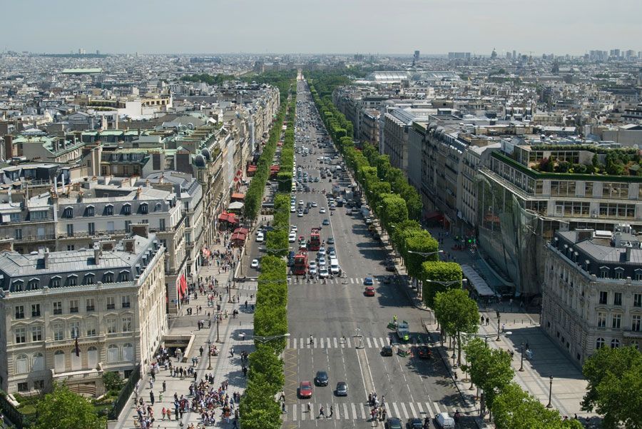 Vista aérea panorámica de los Campos Elíseos en París, Francia. Una larga avenida con coches, árboles y edificios.