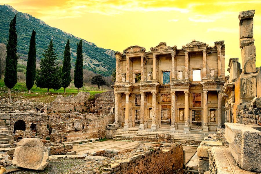 Ruinas de la Biblioteca de Celso en Éfeso, Turquía. Antiguo edificio de piedra con columnas, con un fondo de montañas verdes.