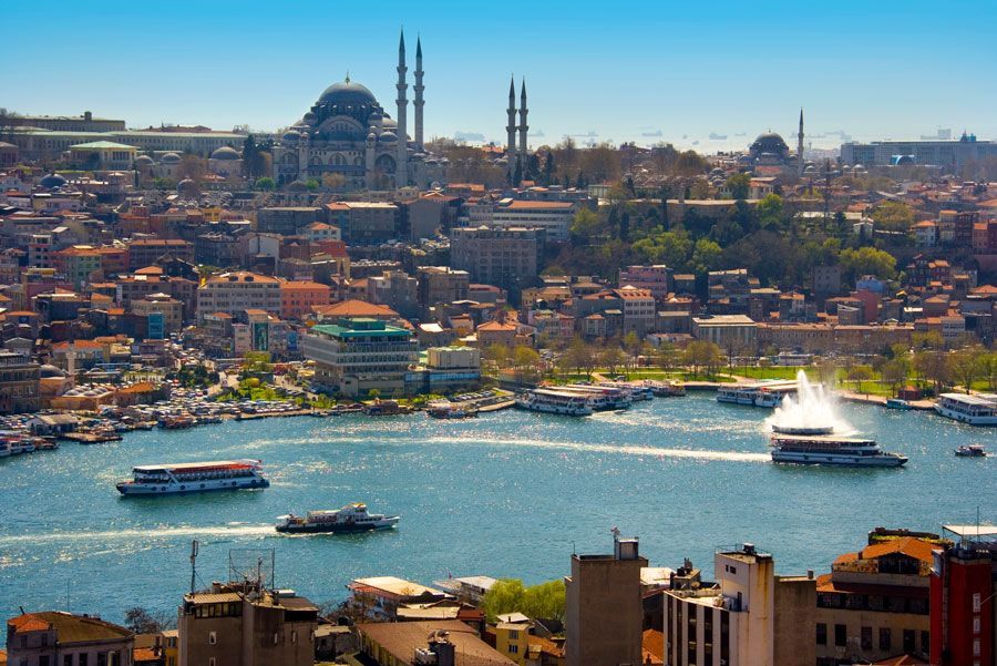 Una vista aérea de Estambul, Turquía, con un puerto con barcos, edificios de la ciudad y una mezquita con minaretes al fondo.
