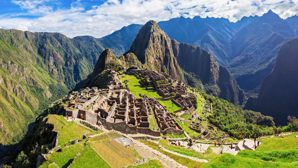 Machu Picchu, Perú: Antigua ciudadela inca ubicada en la Cordillera de los Andes, con ruinas de piedra y exuberantes laderas verdes con un telón de fondo de picos.