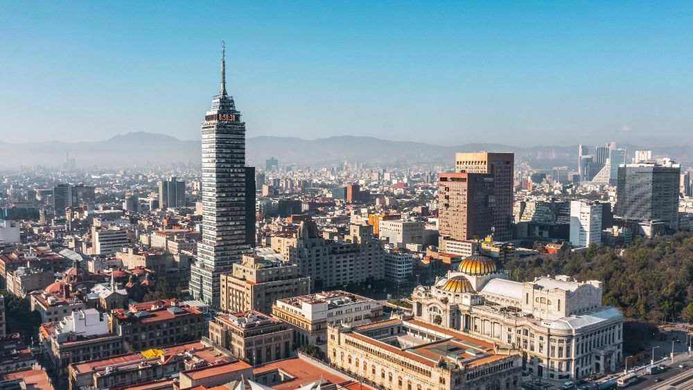 Horizonte de la Ciudad de México con el rascacielos Torre Latinoamericana, otros edificios y el Palacio de Bellas Artes bajo un cielo azul.