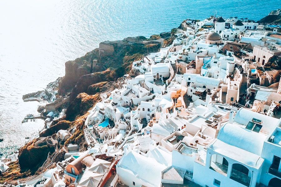 Edificios encalados de Oia, Santorini, Grecia, que caen en cascada por un acantilado hacia el mar Egeo.