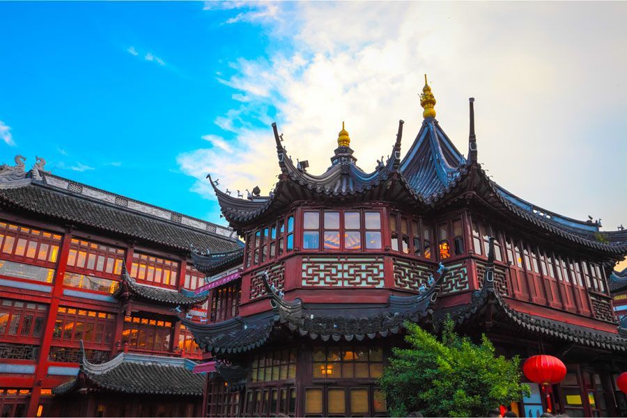 Arquitectura china adornada con detalles en rojo y negro contra un cielo azul.