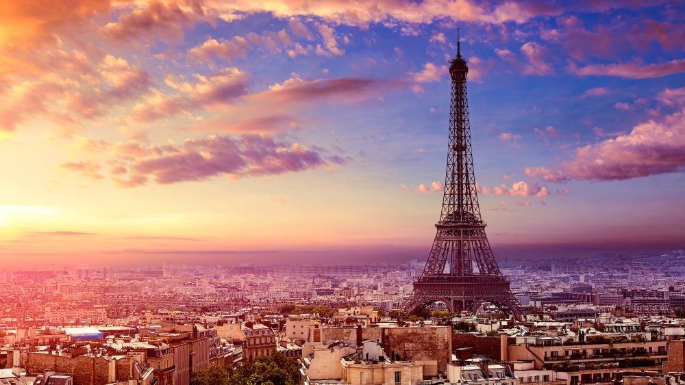 La Torre Eiffel recortada contra una vibrante puesta de sol sobre la ciudad de París, Francia.
