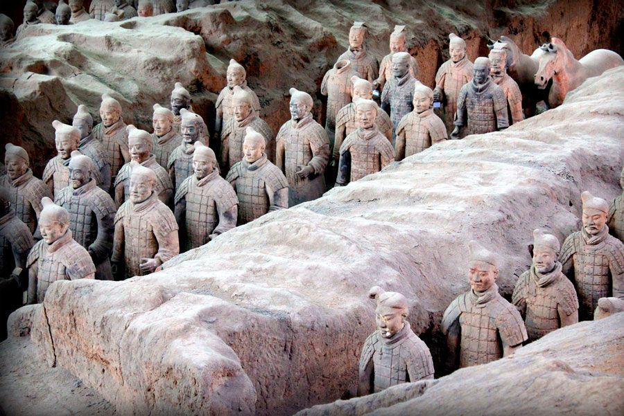 Guerreros de terracota en fila, excavados en el yacimiento del Ejército de Terracota en Xi'an, China. Soldados de arcilla uniformados en tonos terrosos.
