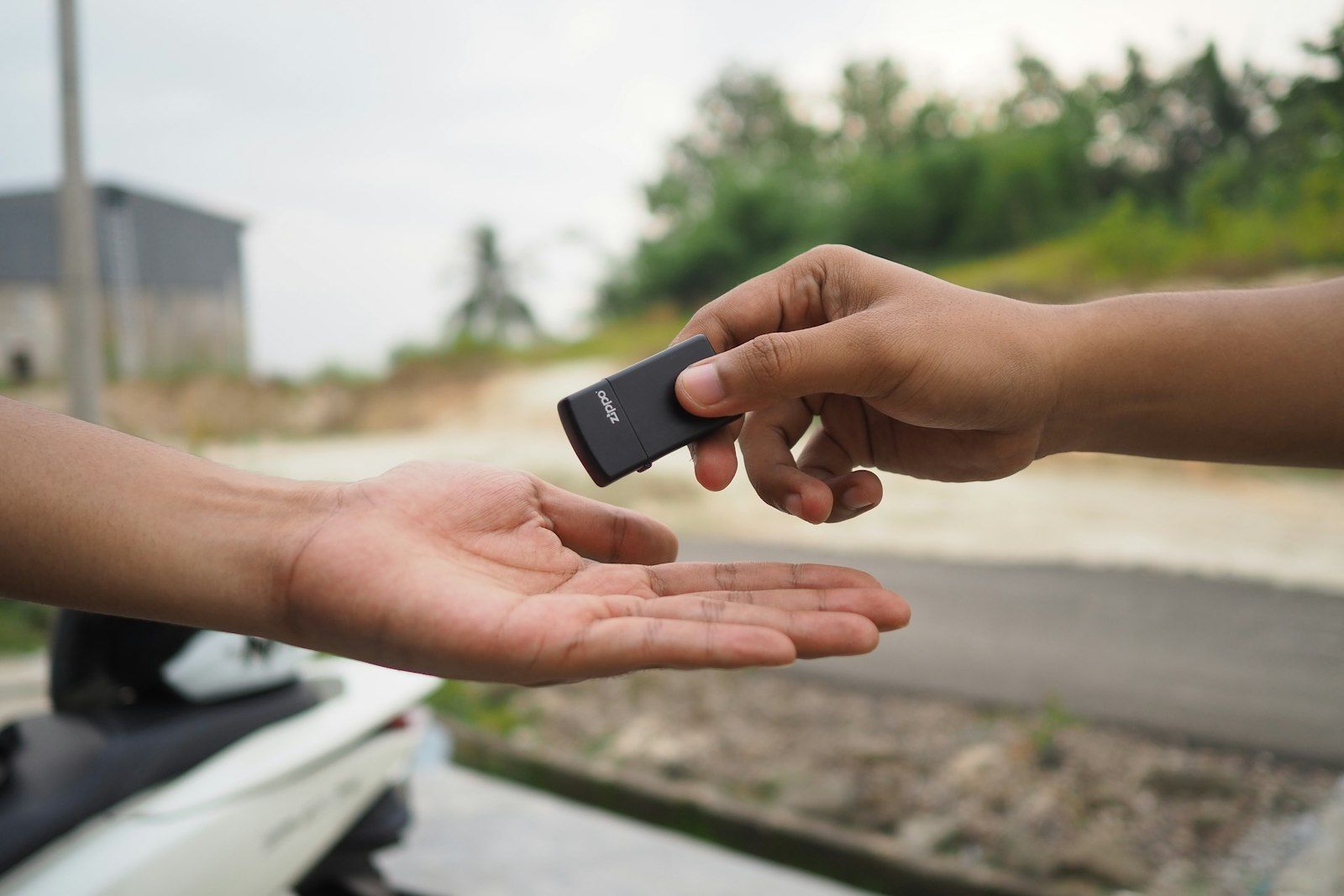 Car key fob being handed from one person to another