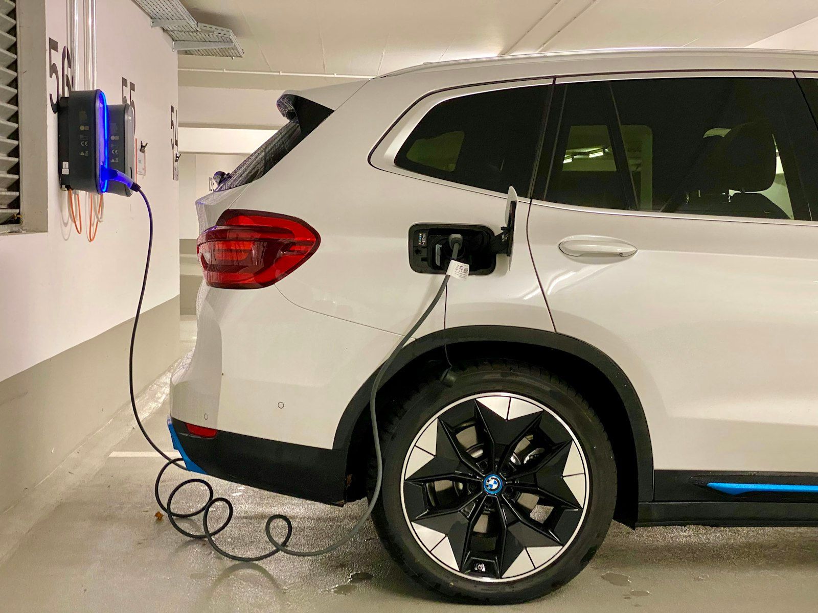 White electric SUV plugged into a charging station