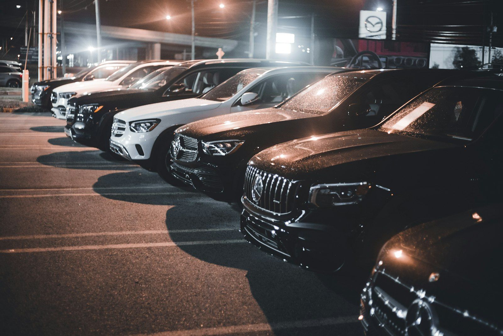 Row of SUVs parked on a dealership lot at night