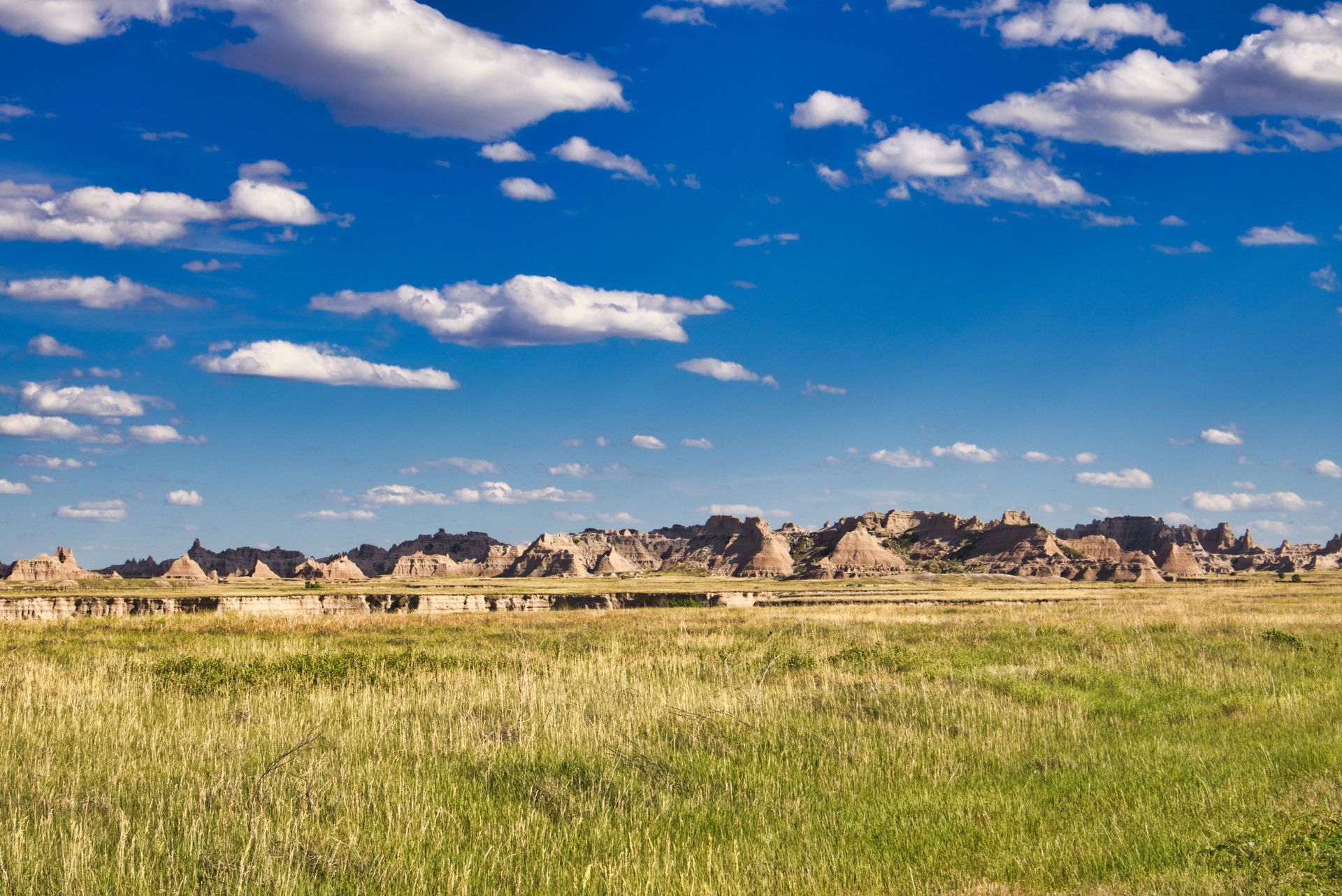The rugged rock pinnacles and rolling green grasslands of Badlands National Park in South Dakota.