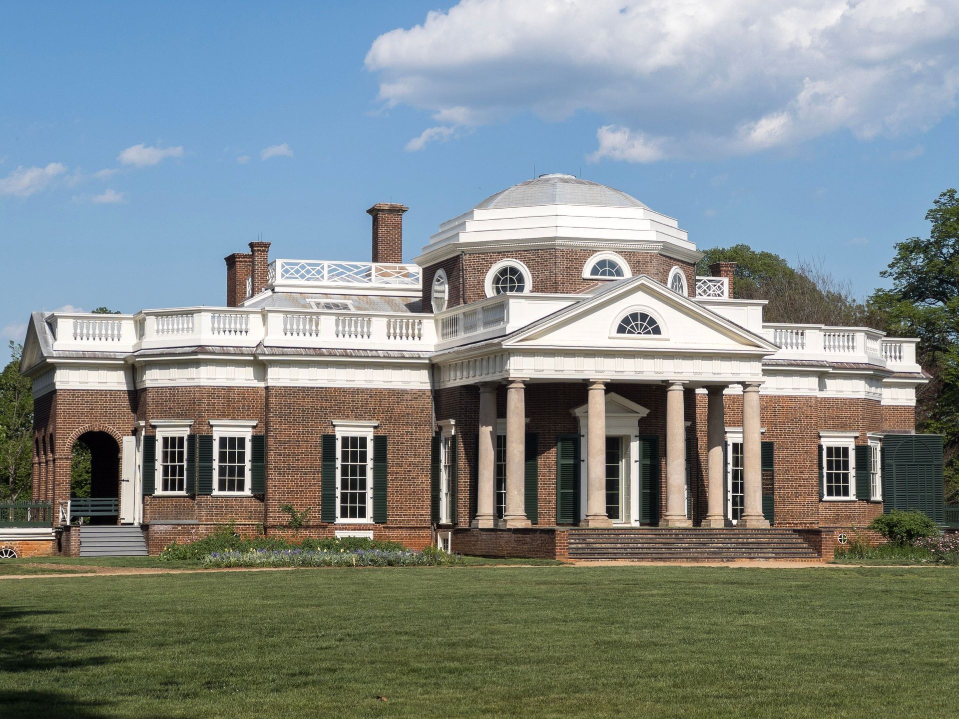 The brick historic Monticello plantation home under a blue sky in Charlottesville, Virginia.