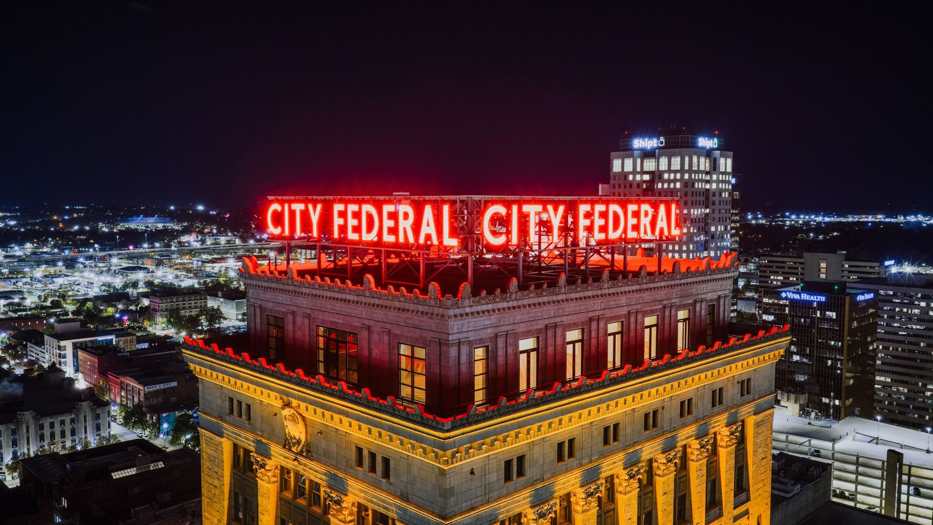 The glowing red neon sign on top of the City Federal Building in Birmingham, Alabama