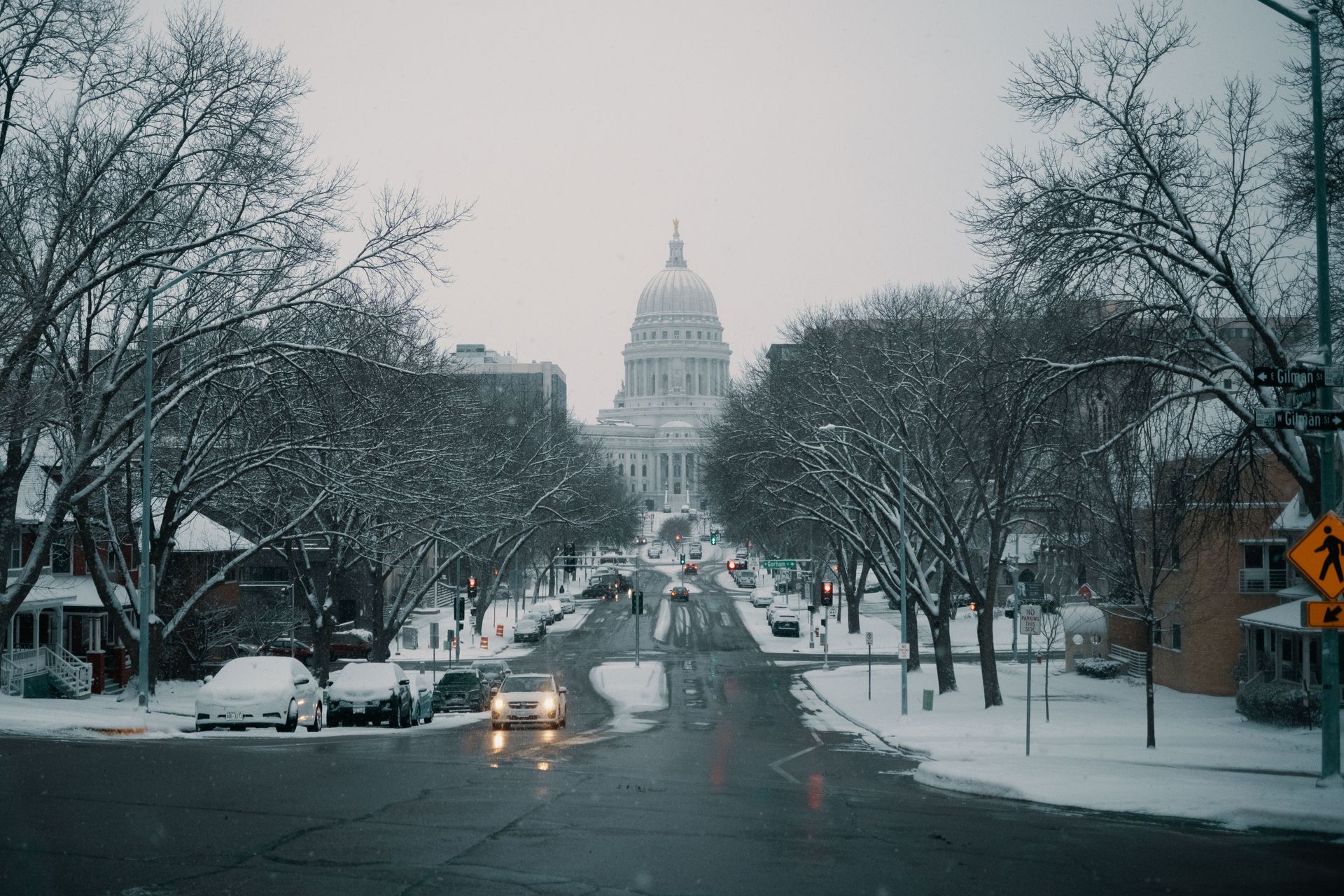Looking down a snow-covered street toward the illuminated Wisconsin State Capitol in Madison, Wisconsin