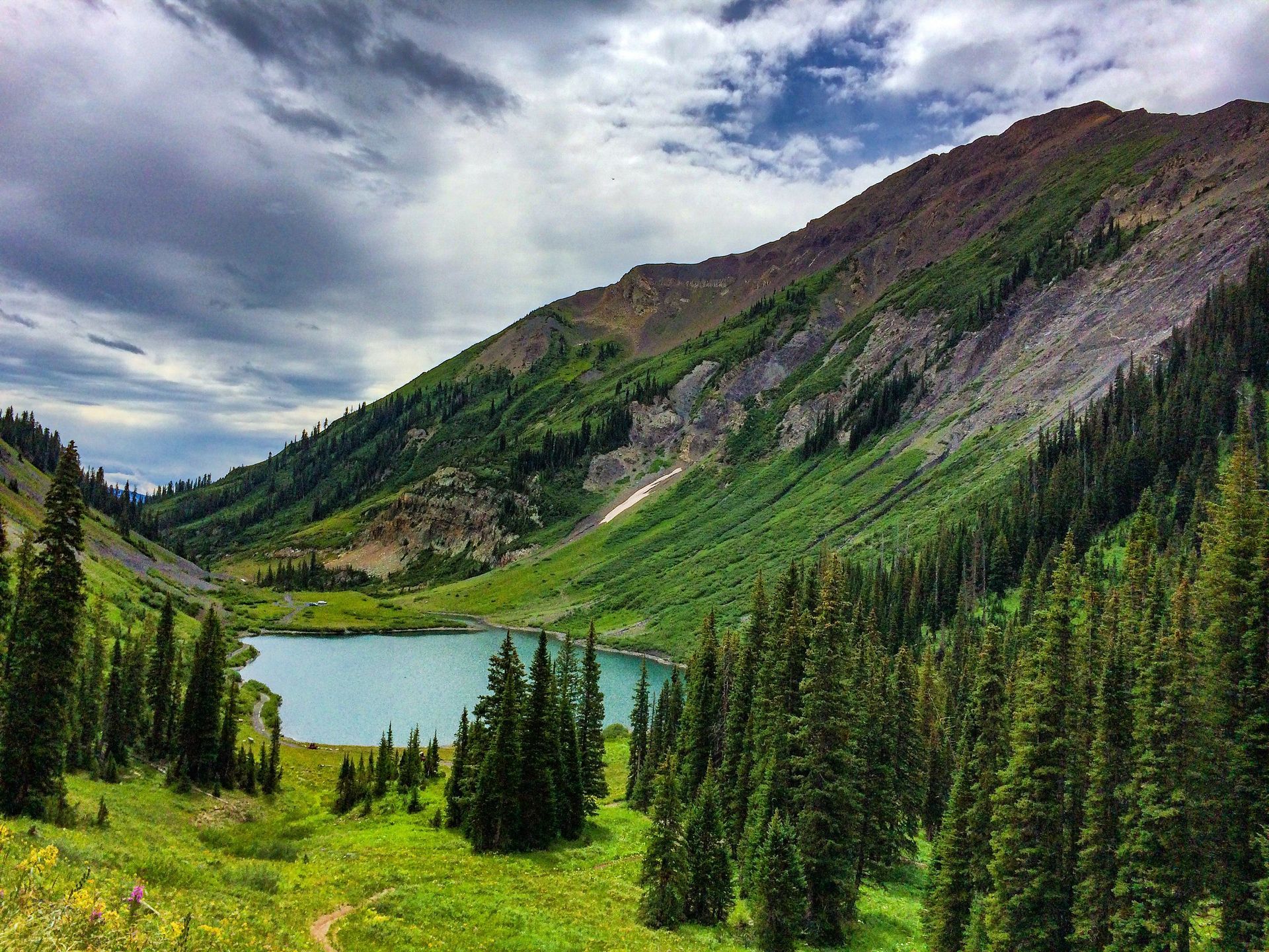 Turquoise waters of Emerald Lake surrounded by pine trees and mountains near Crested Butte, Colorado