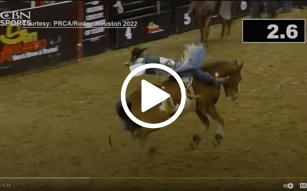 Cowboy riding a bucking horse at a rodeo; timer displays 2.6.