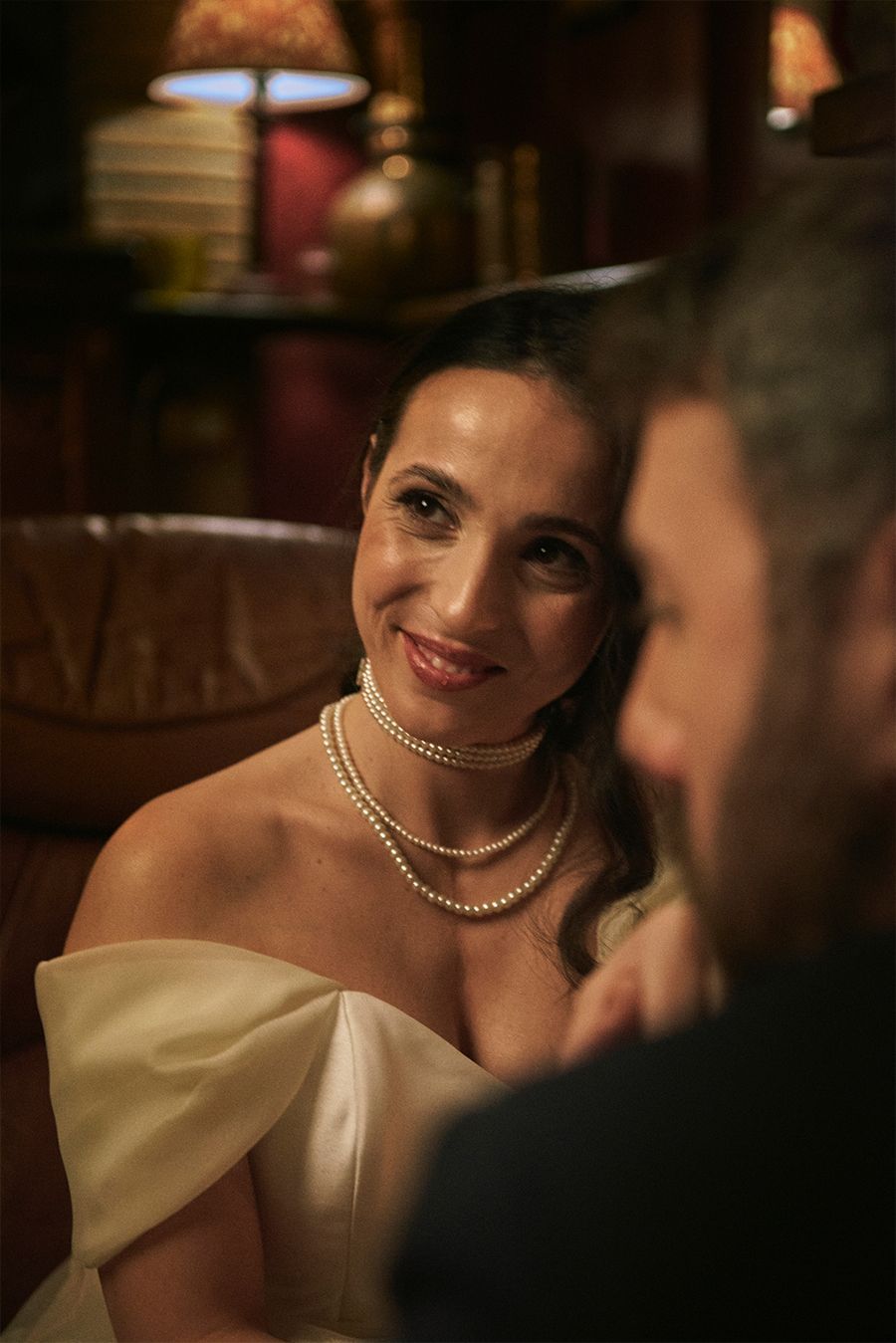 Una donna in abito da sposa è seduta accanto a un uomo in abito.