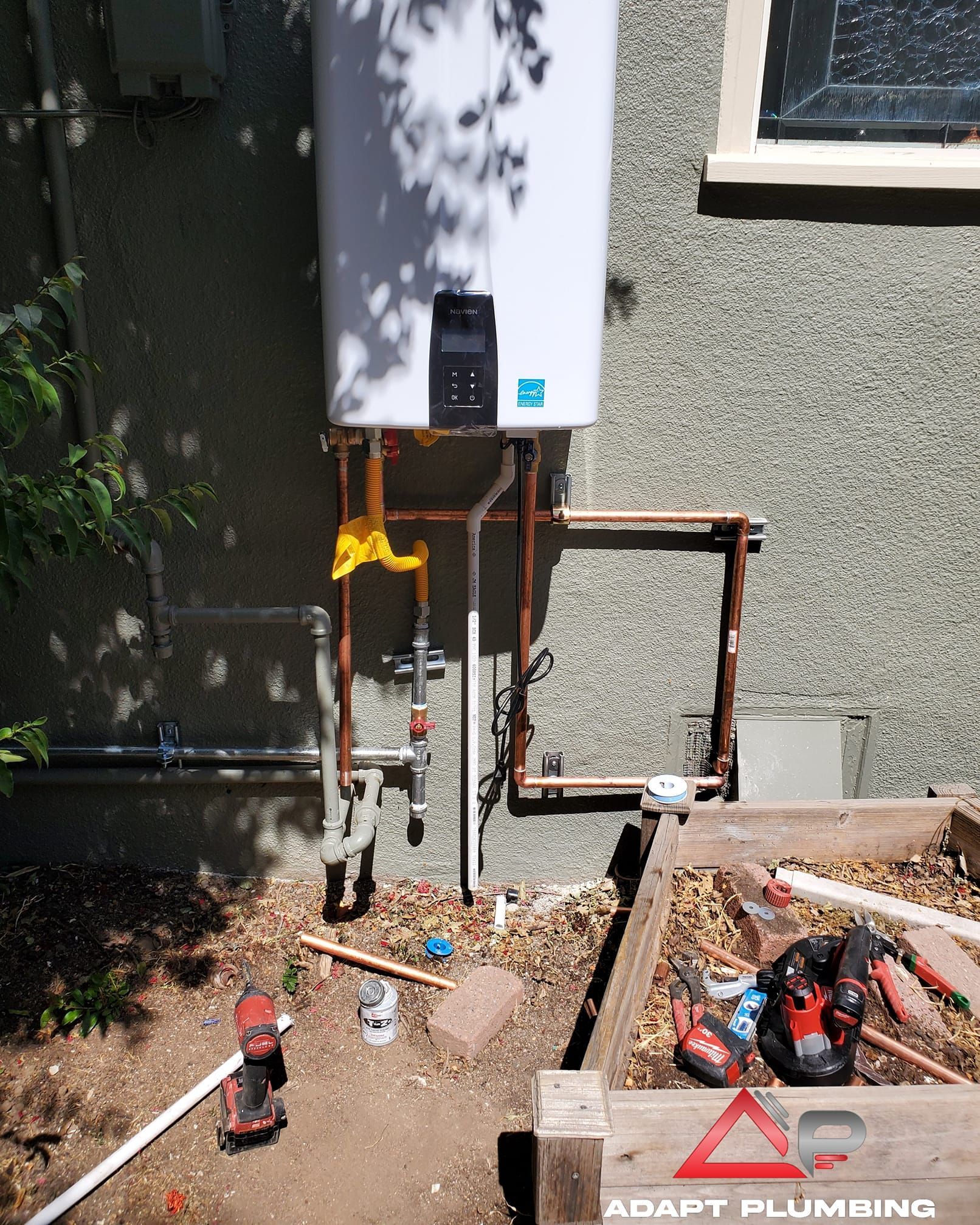 An aerial view of a water heater being installed by adapt plumbing