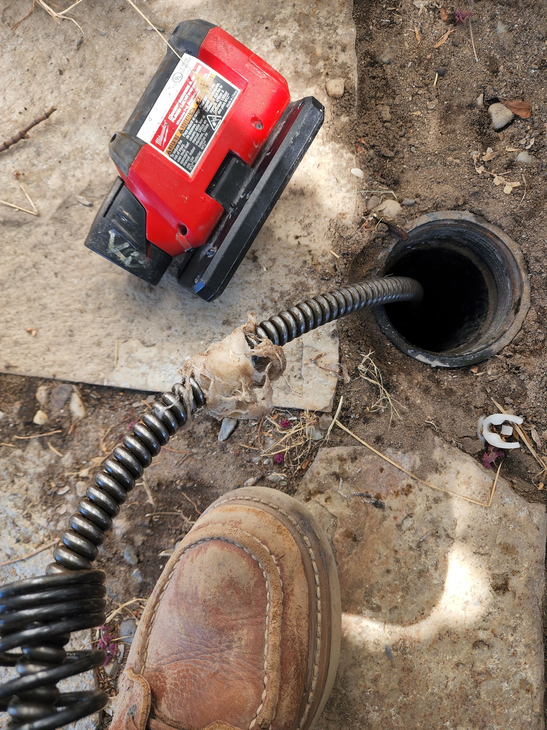 A drain cleaner is being used to clean a drain