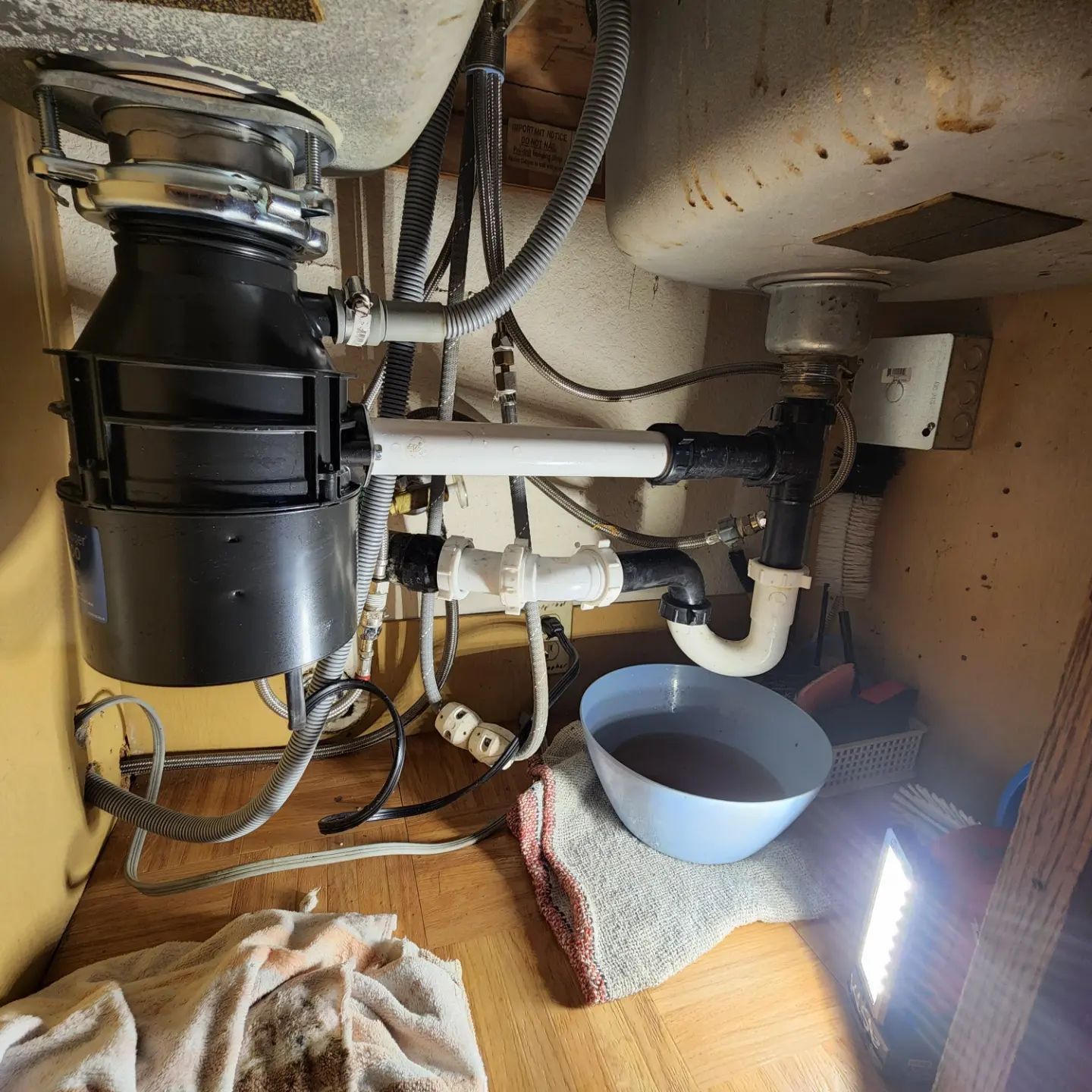A sink with a garbage disposal and a bowl of water underneath it
